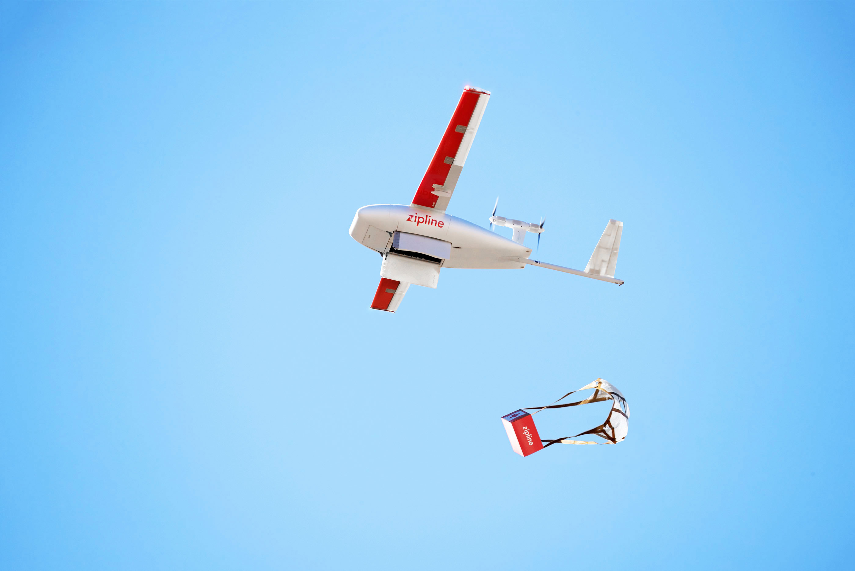 An image of a Zipline airplane dropping a parachuted box