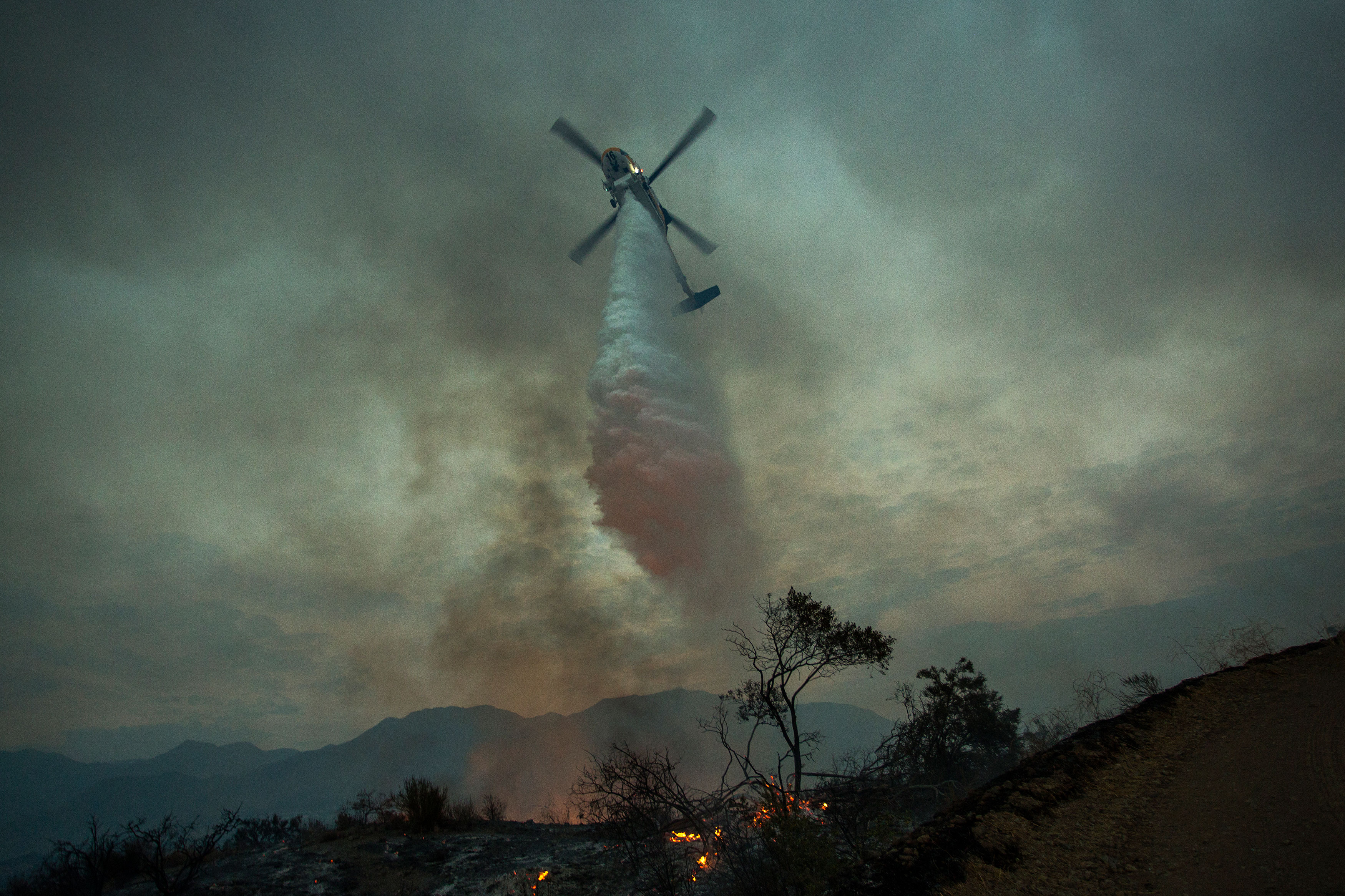 Photo of a helicopter extinguishing a forest fire