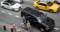 Traffic surrounds a ride-hailing taxi picking up passengers in New York