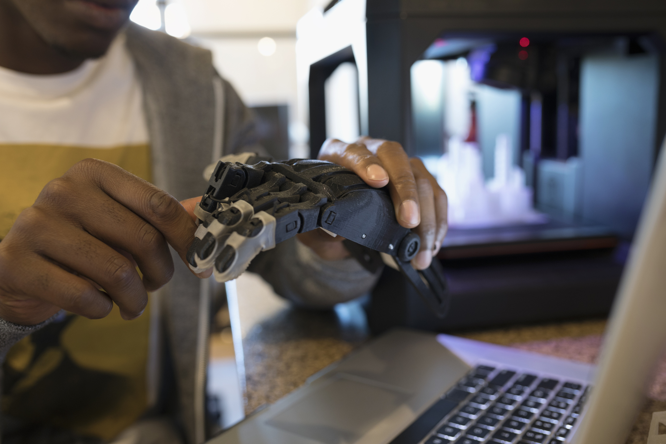 An image of a developer holding a robotic hand