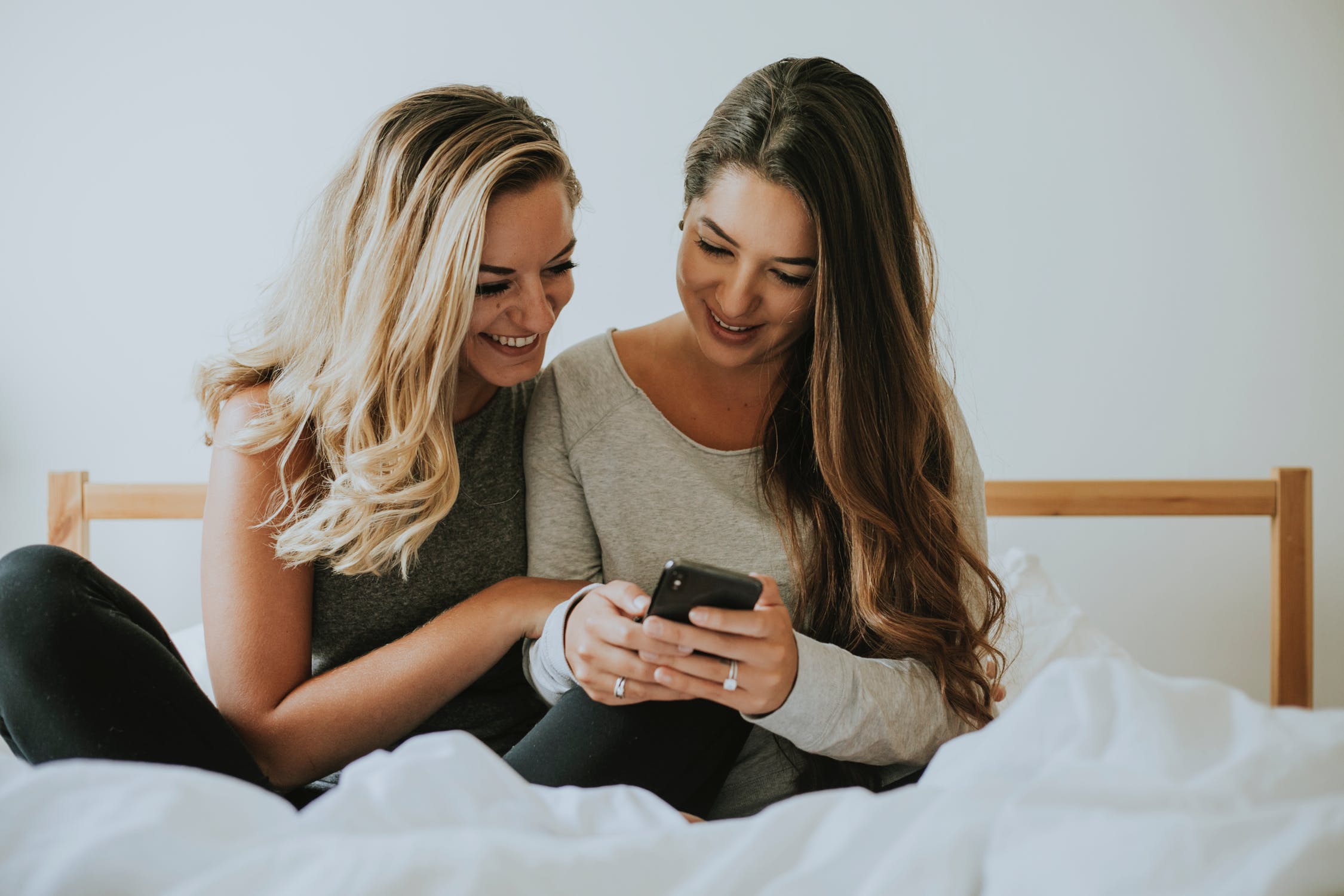 image of teen girls on bed looking at phone sexting sextortion selfie