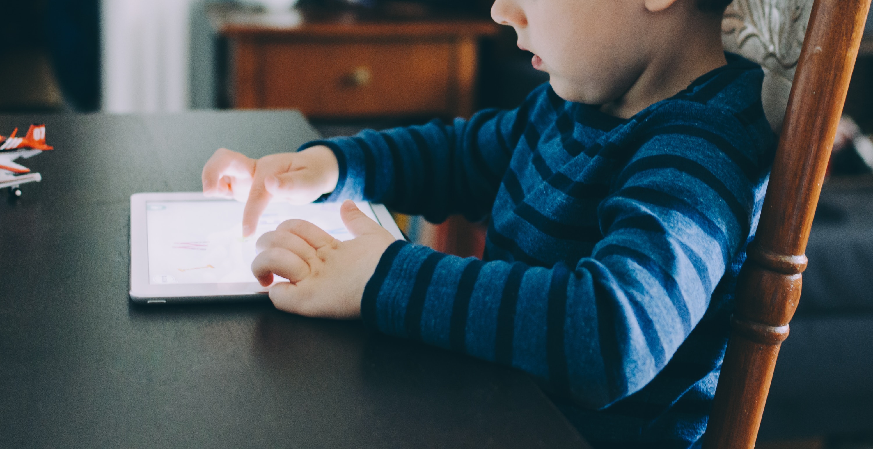image of child typing on ipad screen