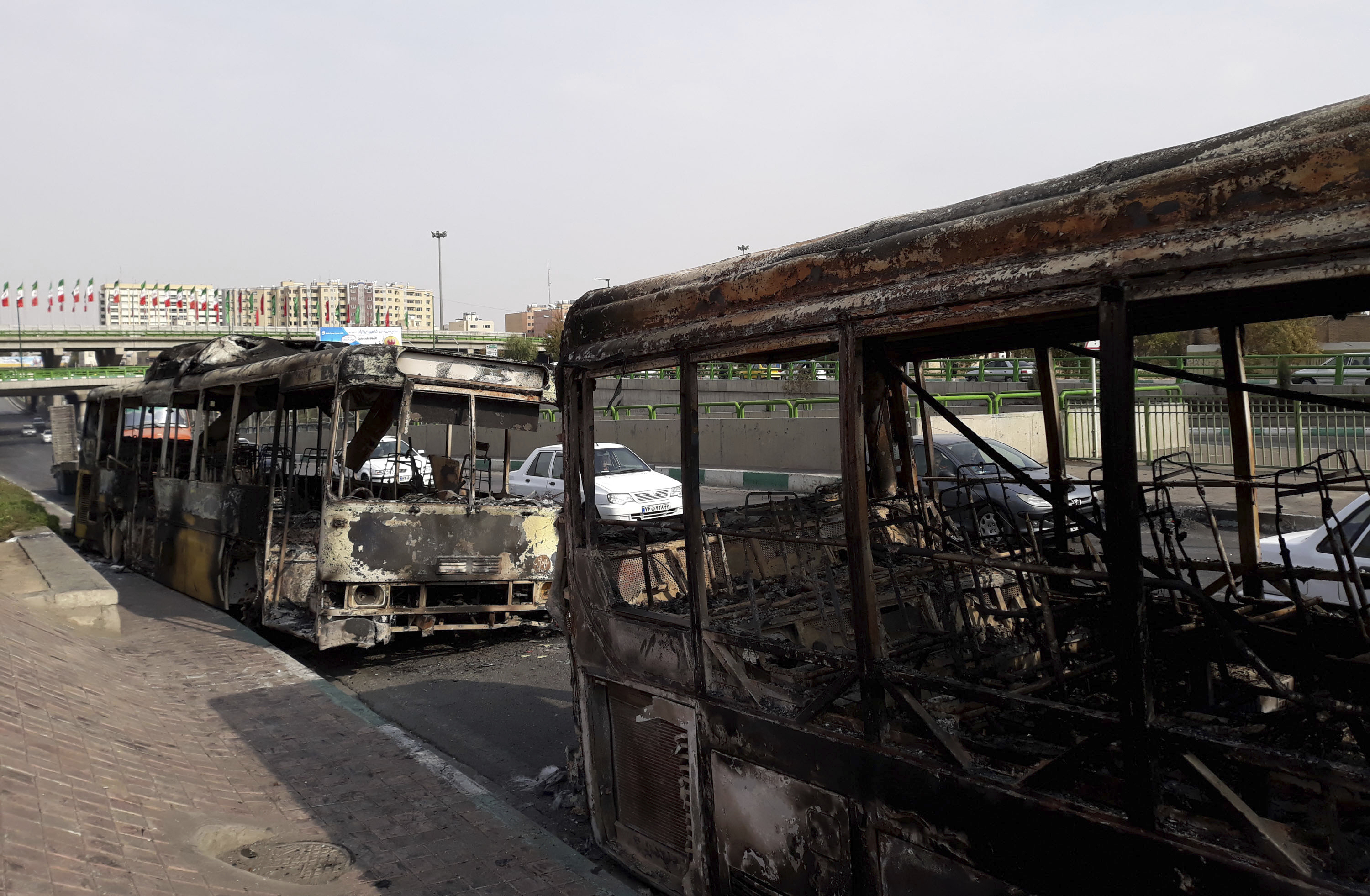 Scorched public buses that remained on the street in Tehran, Iran, after protests that followed authorities&#039; decision to raise gasoline prices