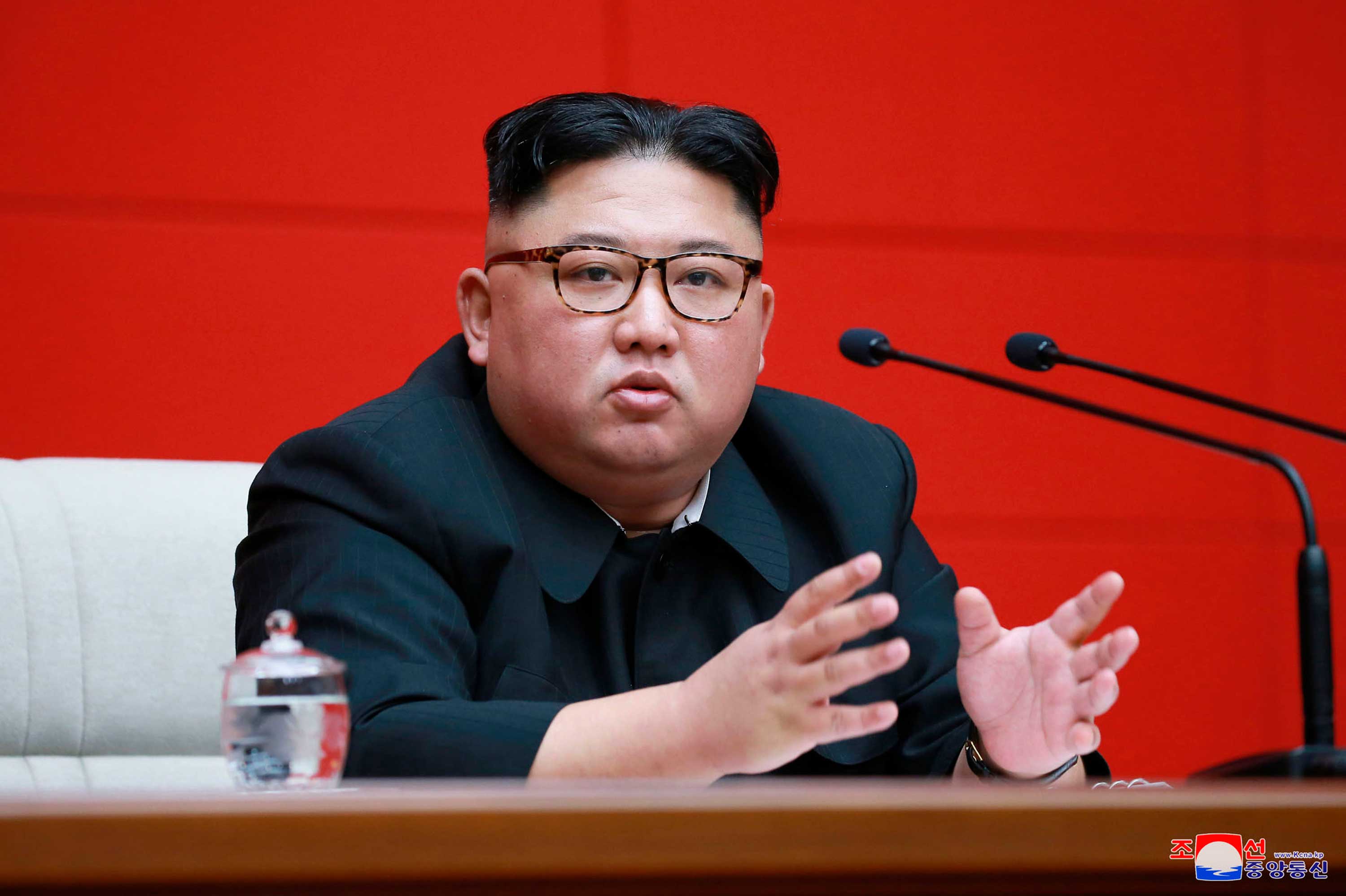 North Korean leader Kim Jong-un speaks into a microphone.