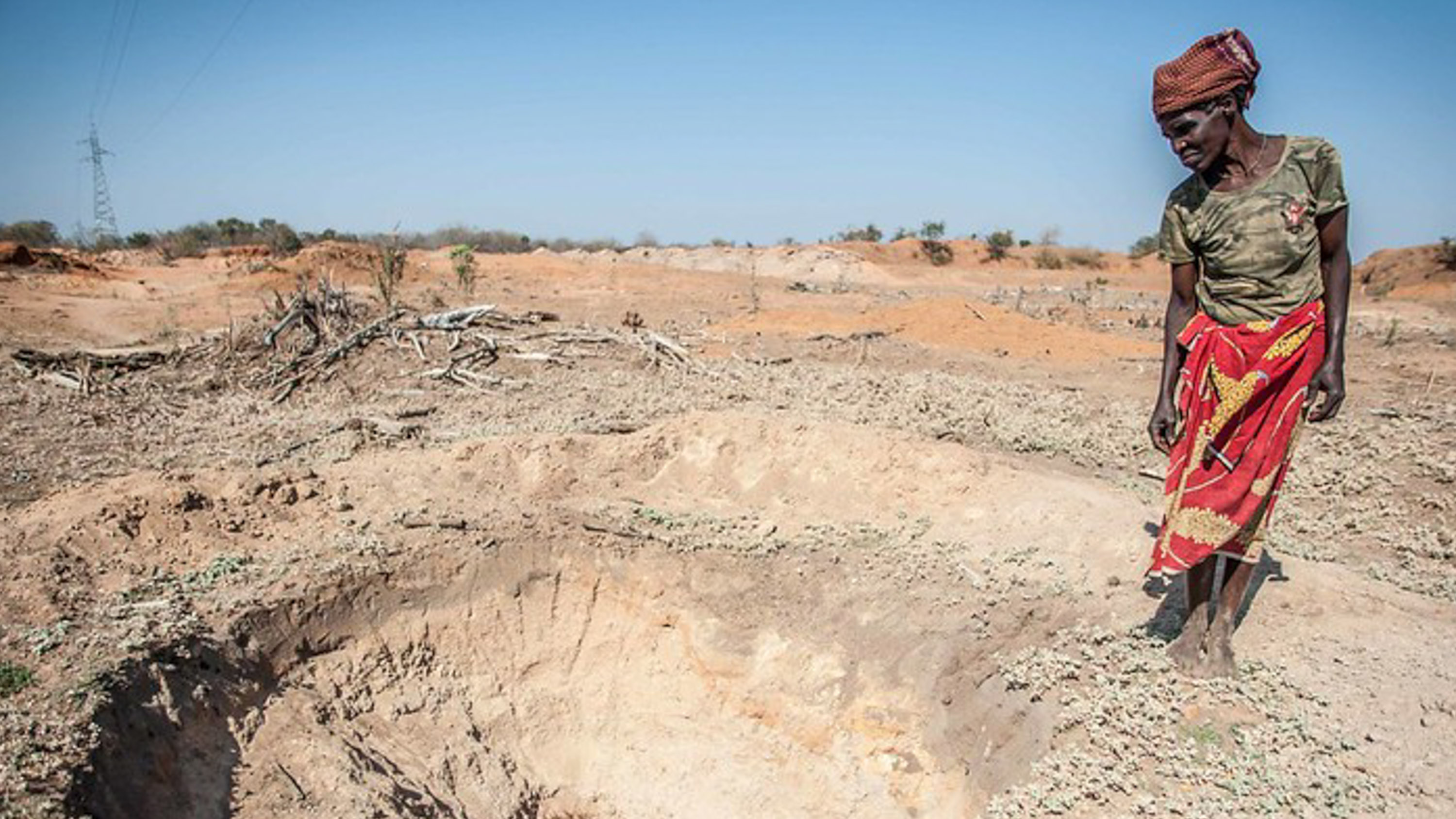 Adelaide Maphangane stands beside an empty water hole in Mozambique, amid a drought in Southern Africa in 2016.