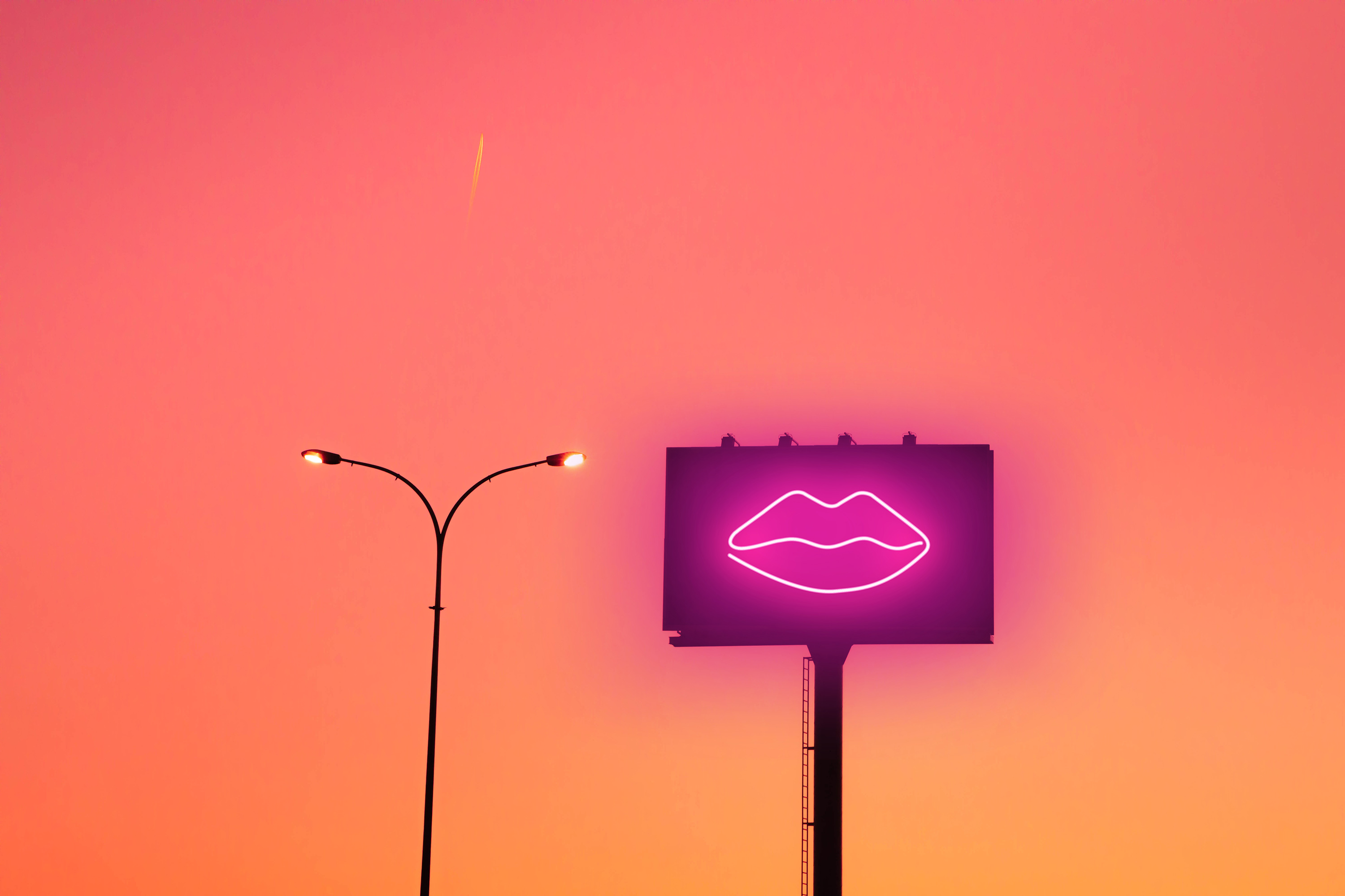 image of lips on billboard next to street light with sunset in background sex tech ces vibrator
