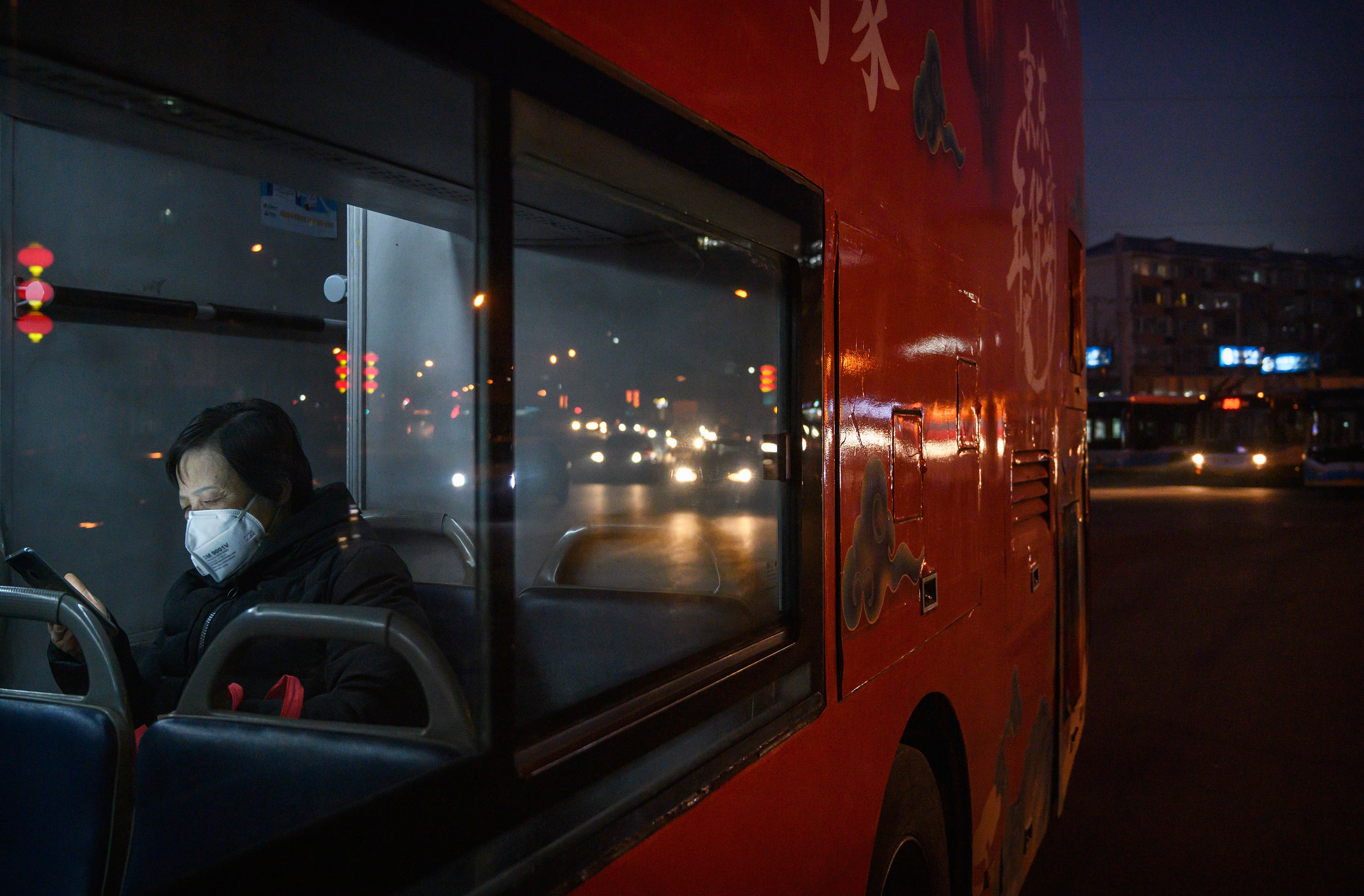 Beijing woman riding bus using mobile phone