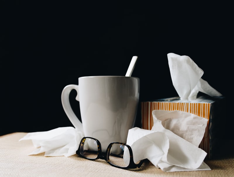 coronavirus vs flu image of coffee mug tissues bedside table influenza