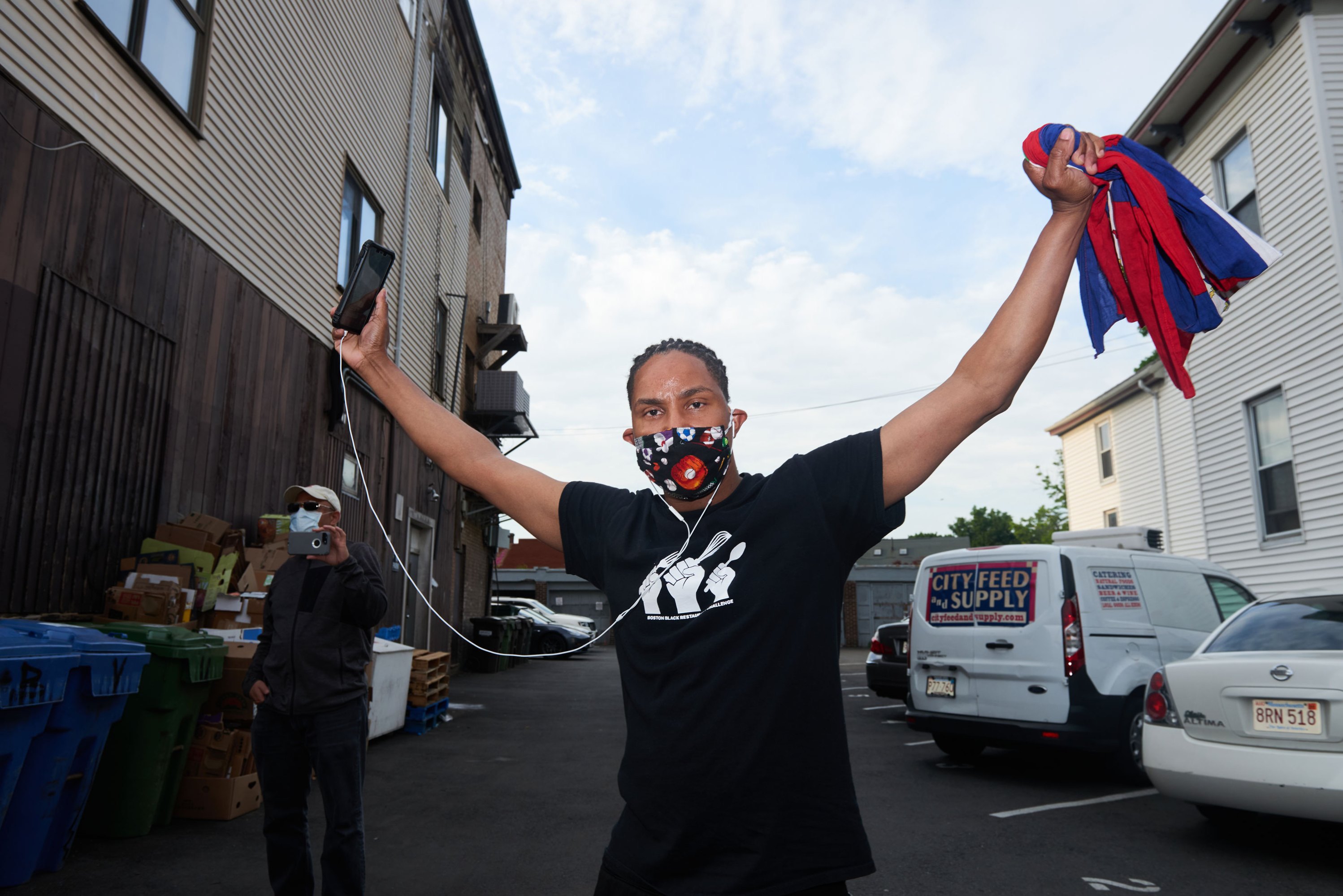   Foto de un manifestante en JP con un teléfono inteligente y una máscara facial. 