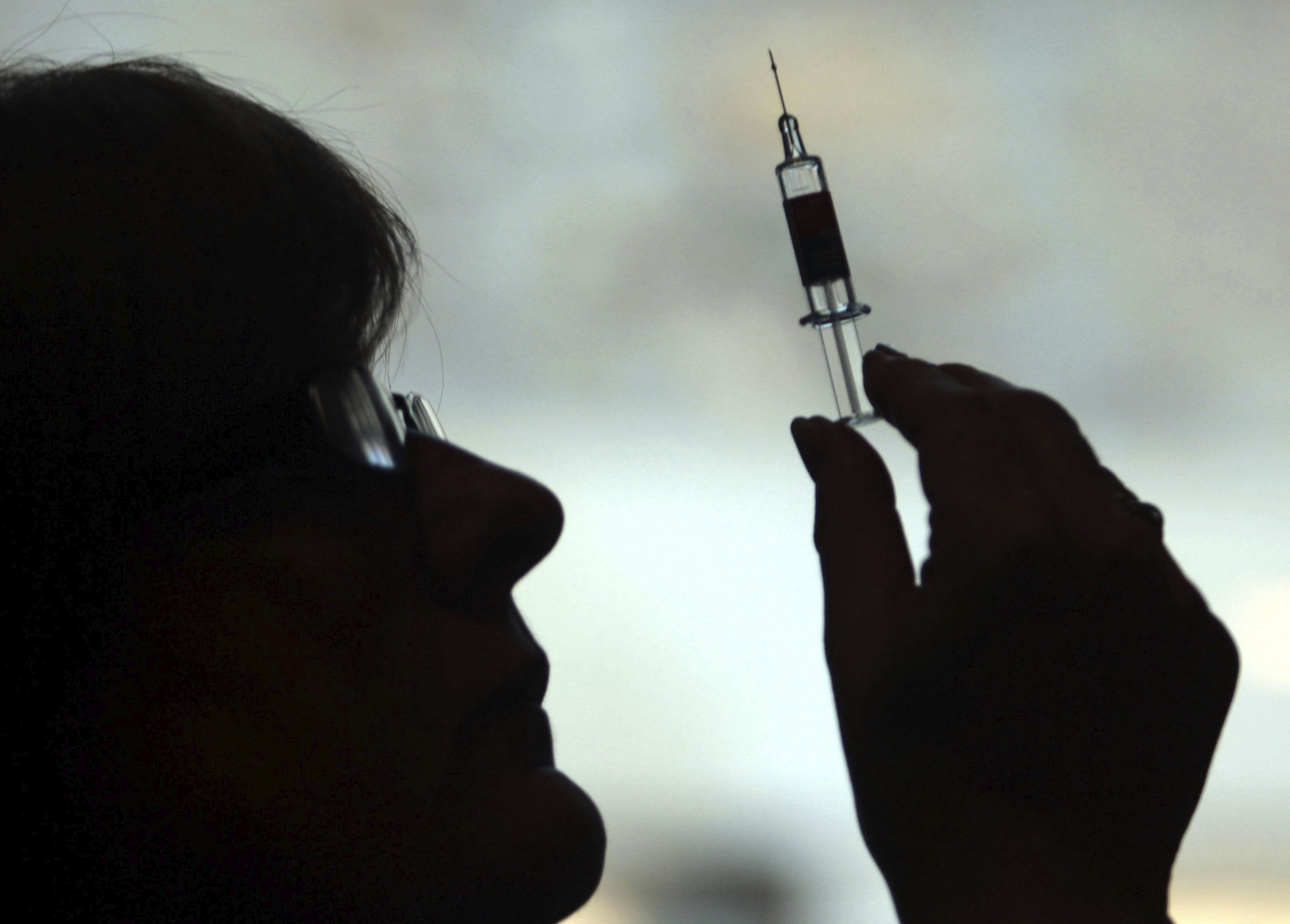 A nurse holds up a vaccine