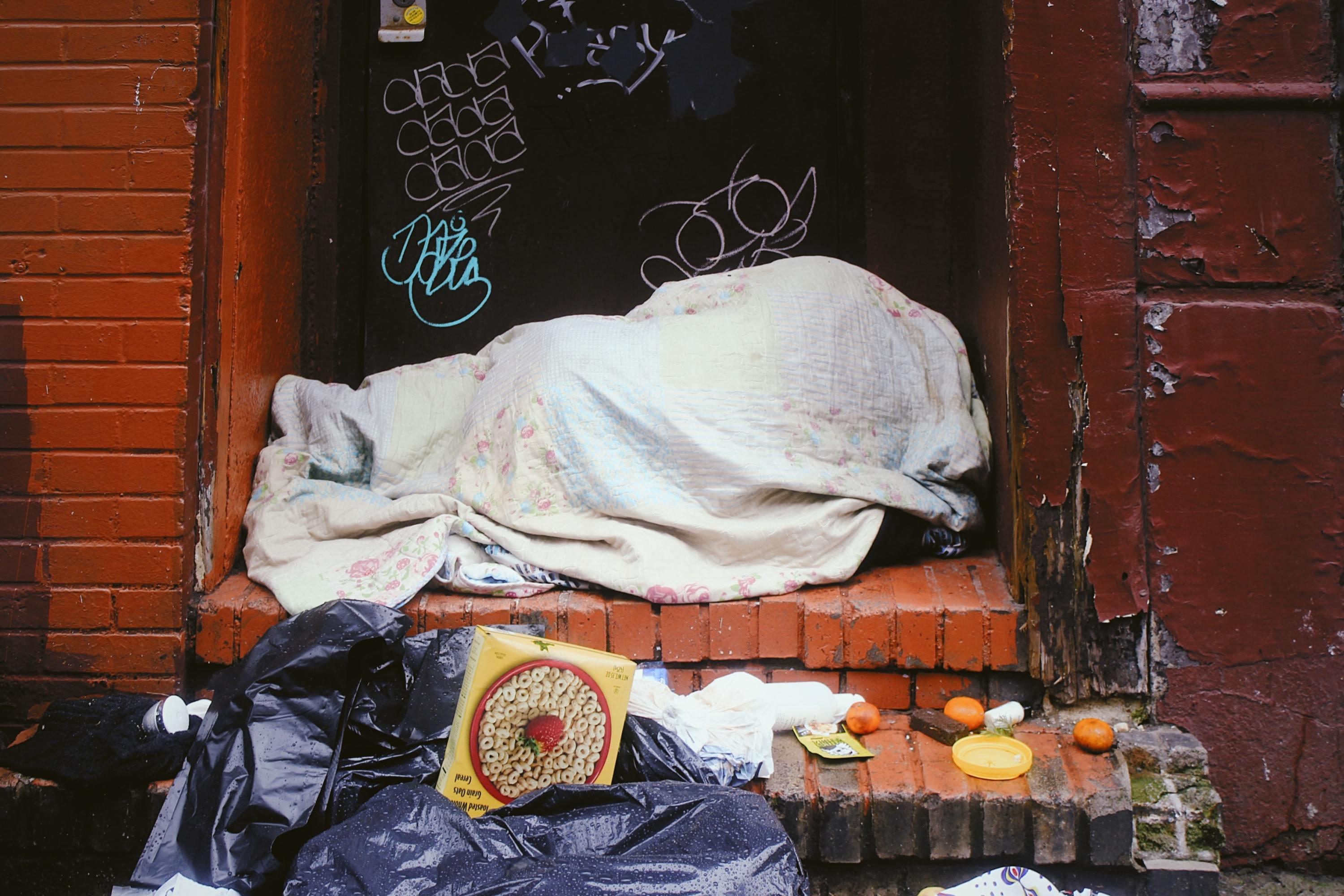 Una persona sin hogar abrigada en la calle.