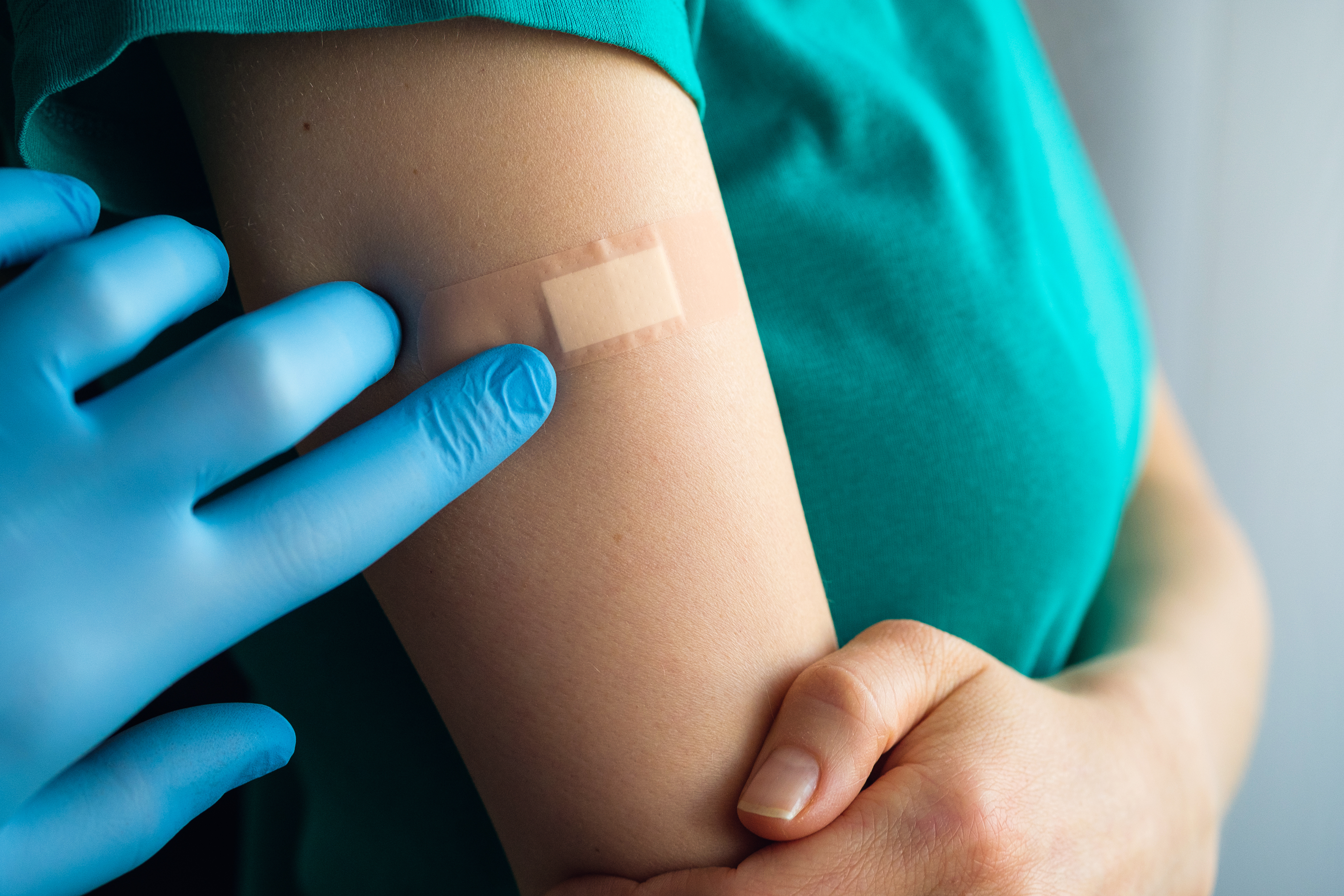 A doctor or health care professional applies a patch or adhesive