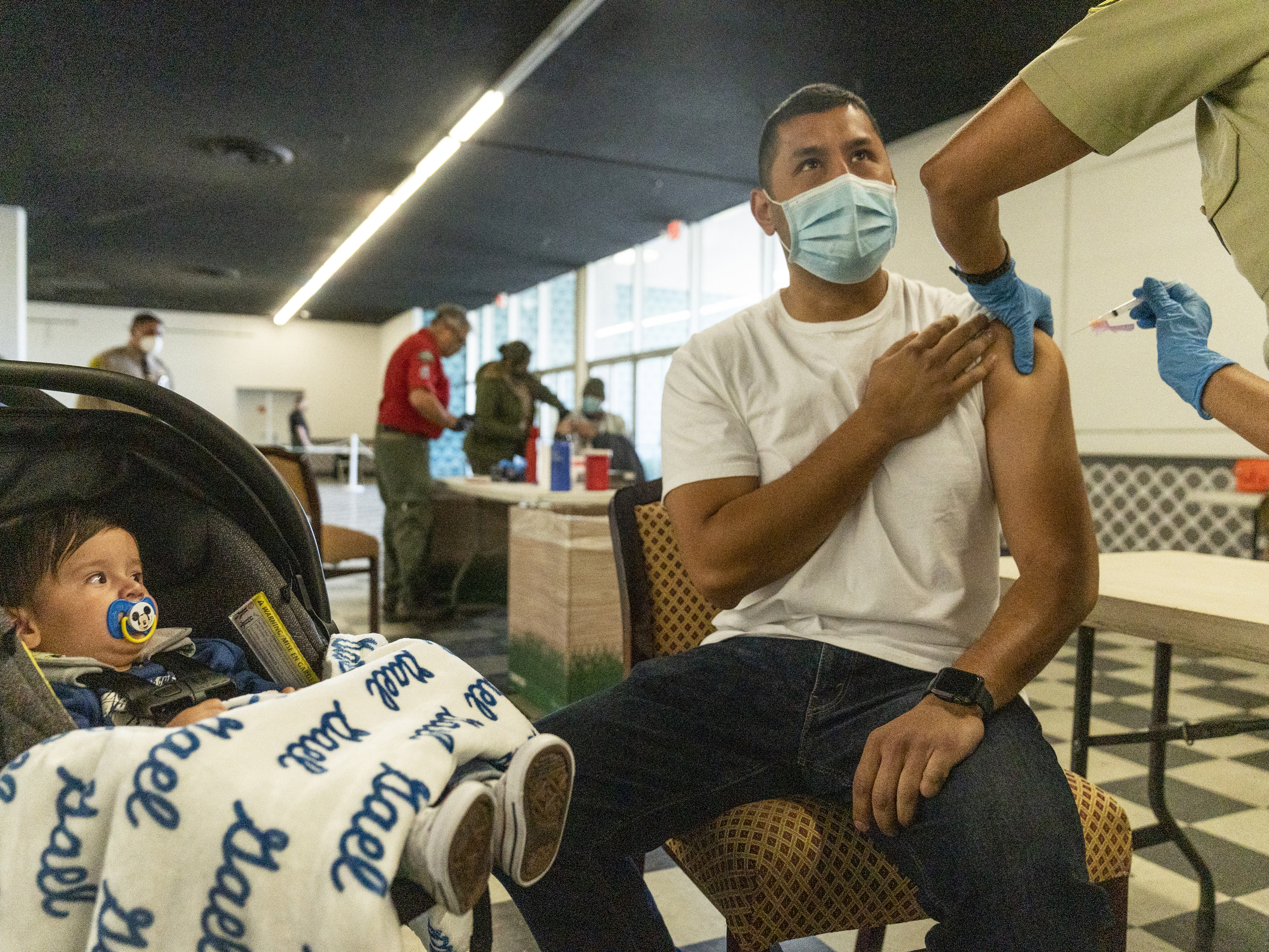 A sheriff&#039;s deputy is inoculated with the Moderna vaccine at a mobile clinic in Pomona, California