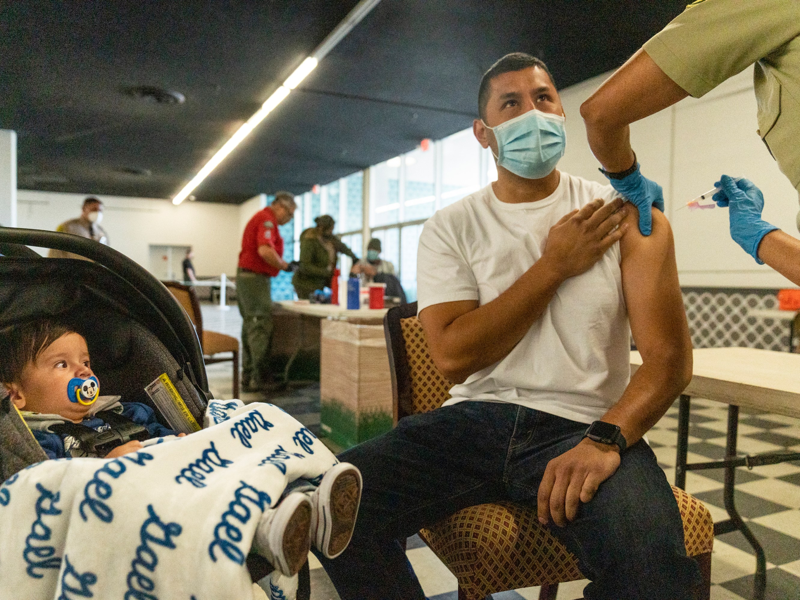 A sheriff's deputy is inoculated with the Moderna vaccine at a mobile clinic in Pomona, California