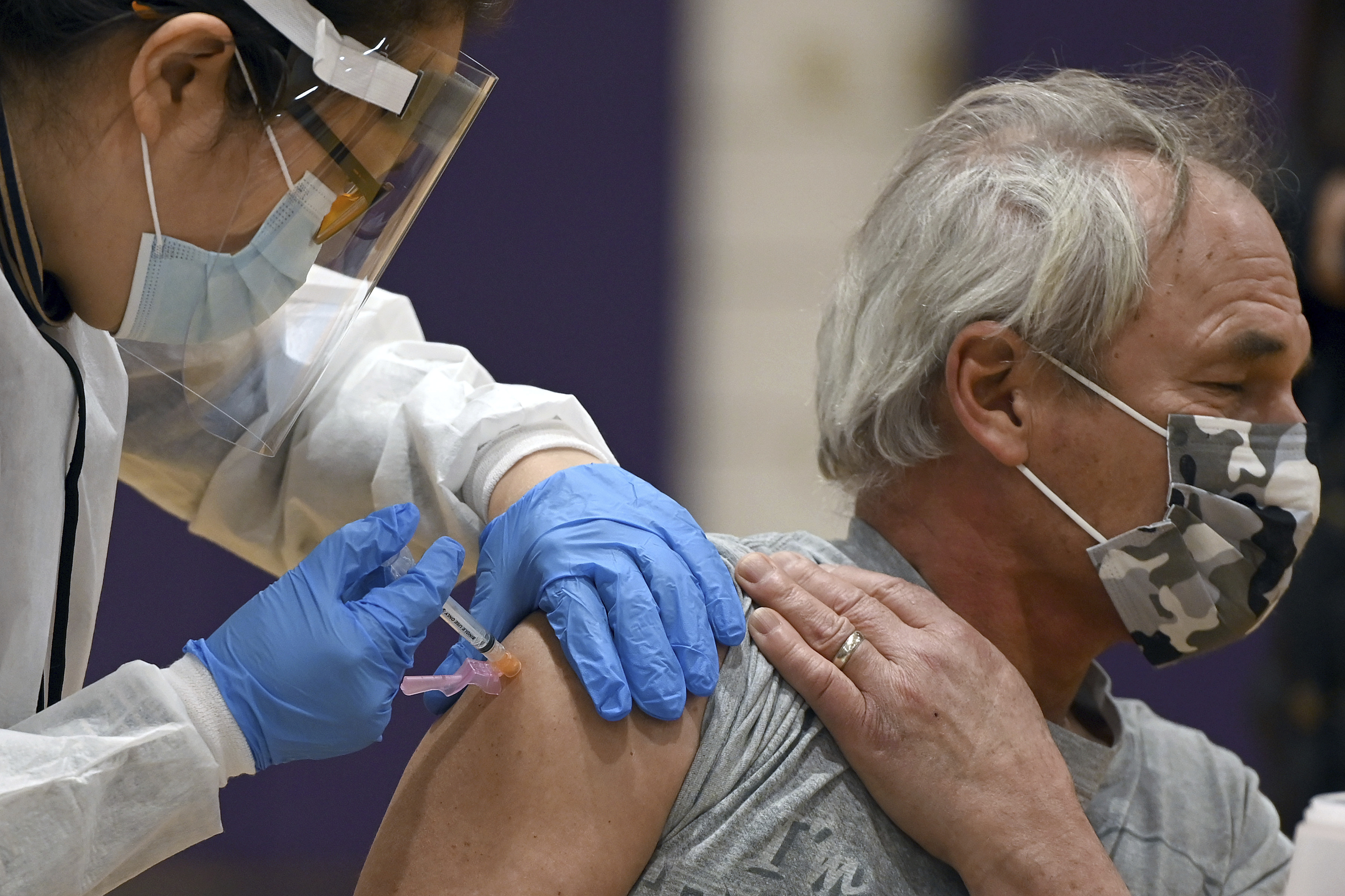 A man recieves a dose of Moderna COVID-19 vaccine inside Hillcrest High School, a designated New York City priority vaccination center for people in group 1B, in the Queens borough of New York City