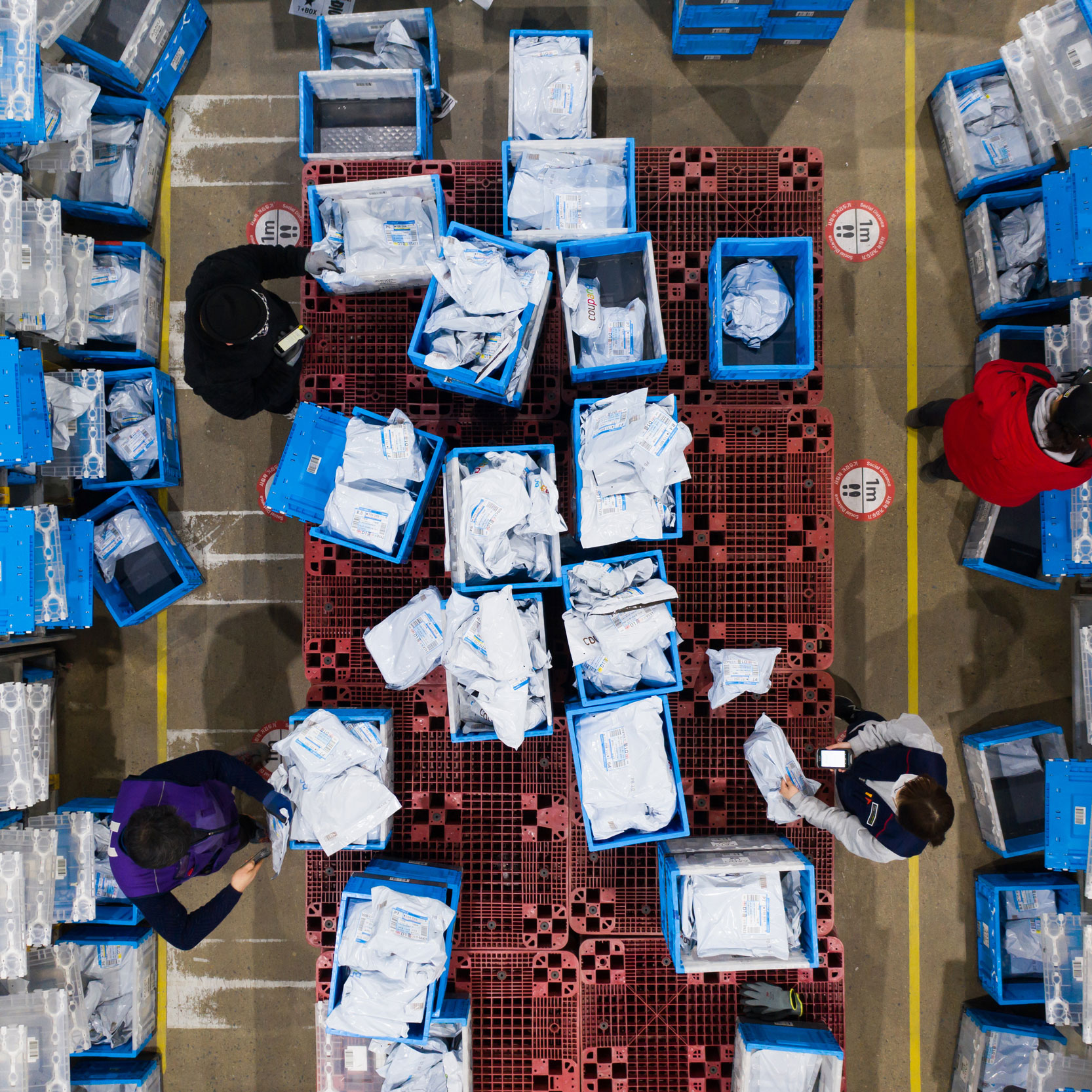 overhead photograph showing a logistics center with employees surrounded by boxes