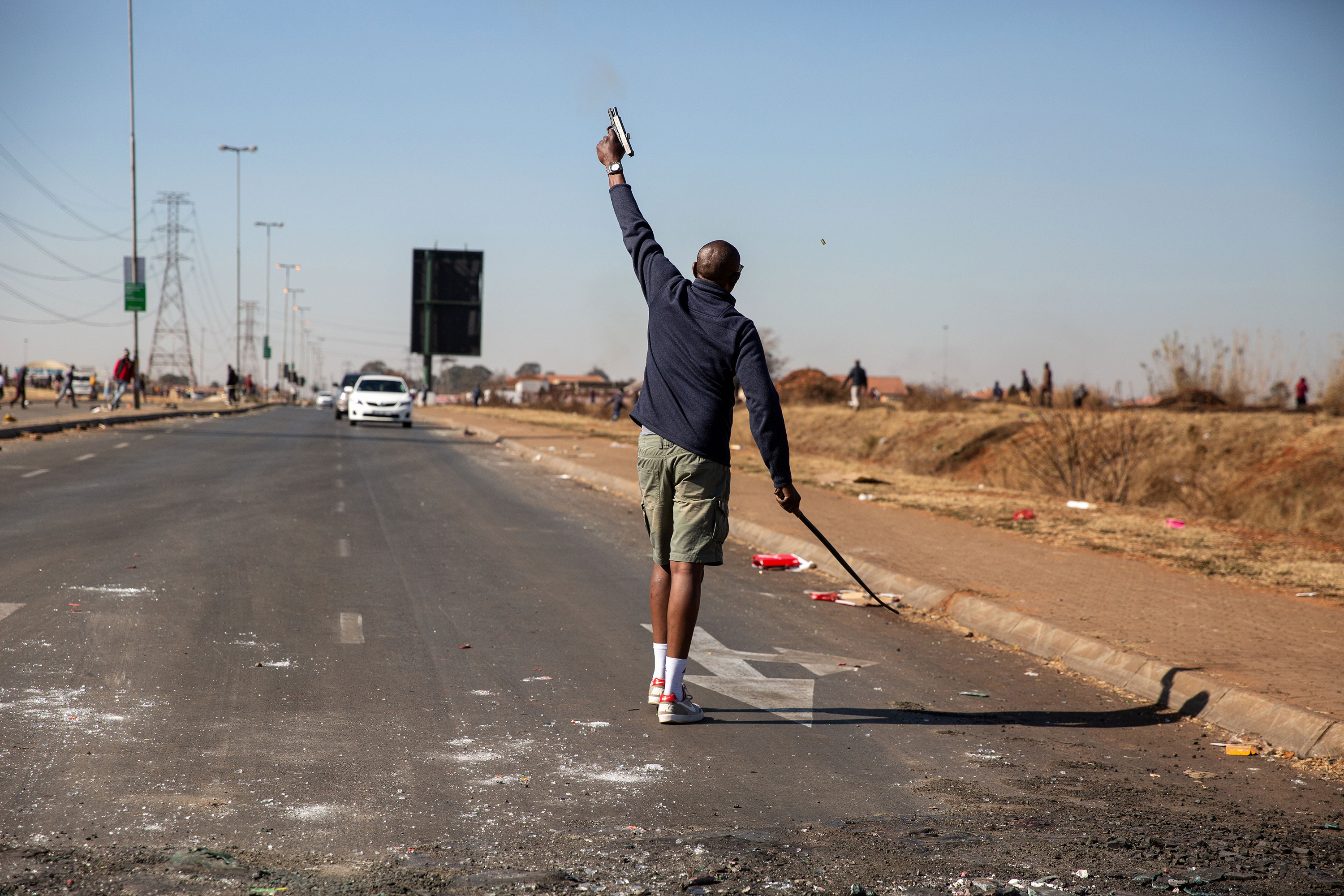 a person shoots a weapon into the air on a road in south africa.