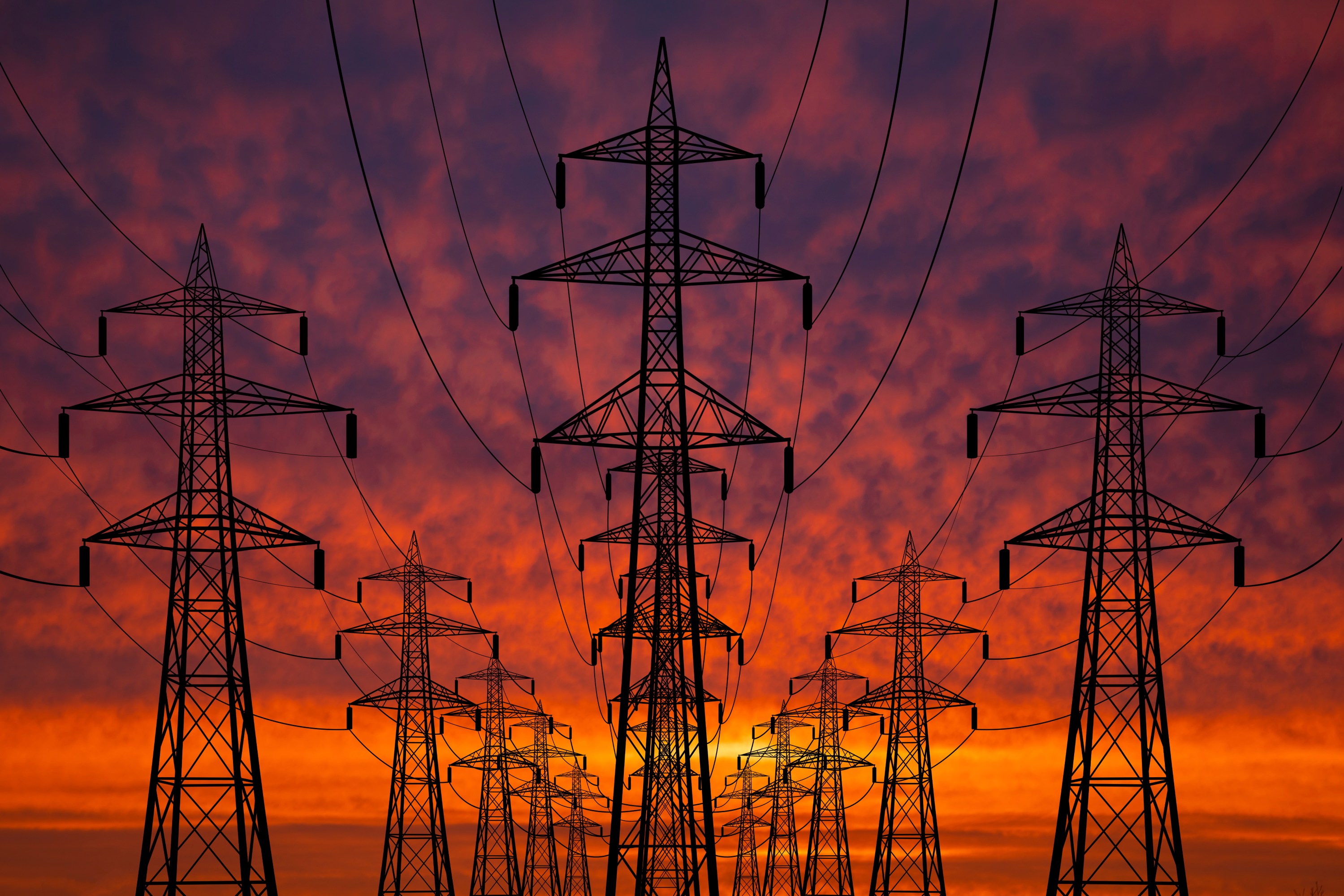 Photograph of High voltage towers at sunset. Power lines against the sky