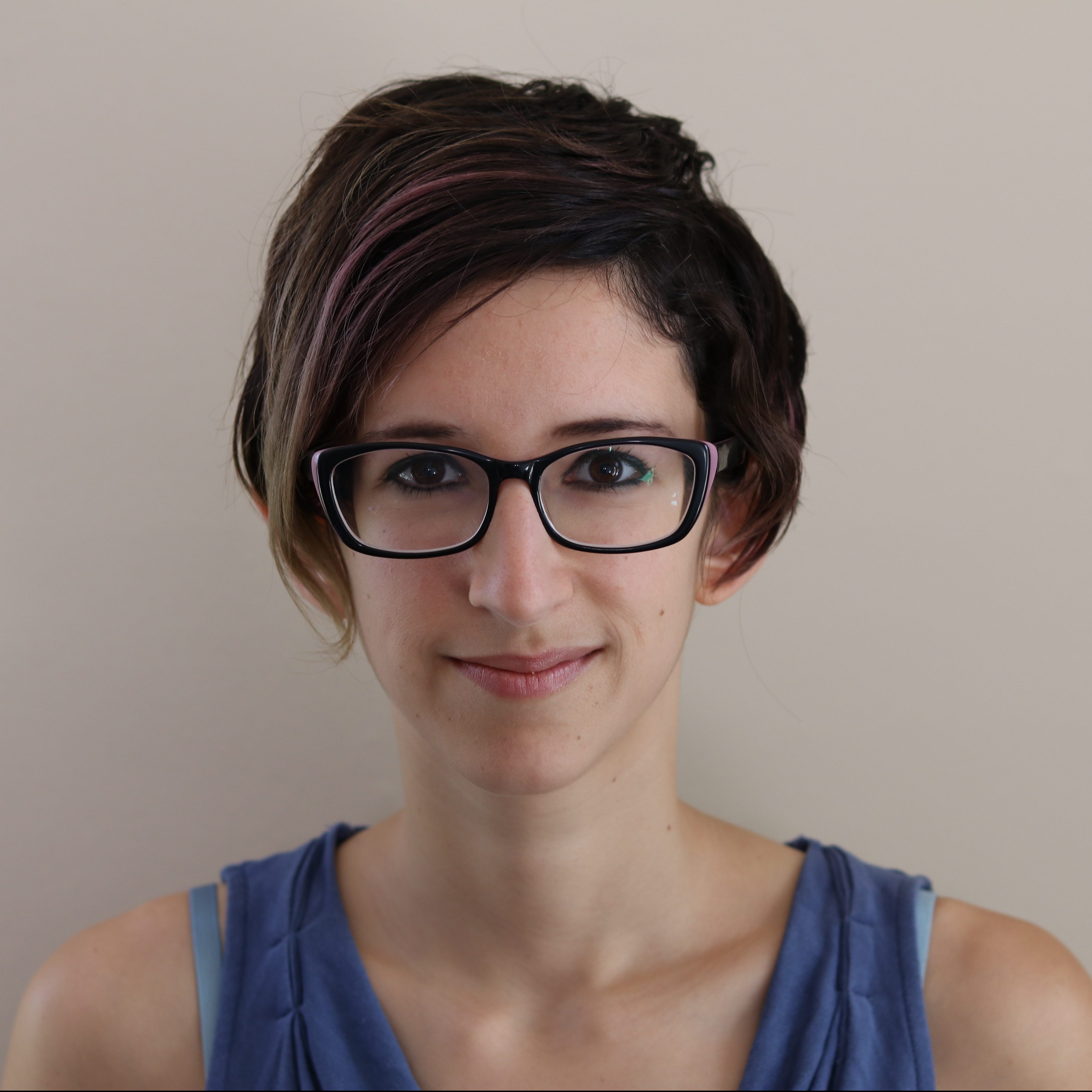 A photo of a person with short hair wearing glasses looking straight into the camera.