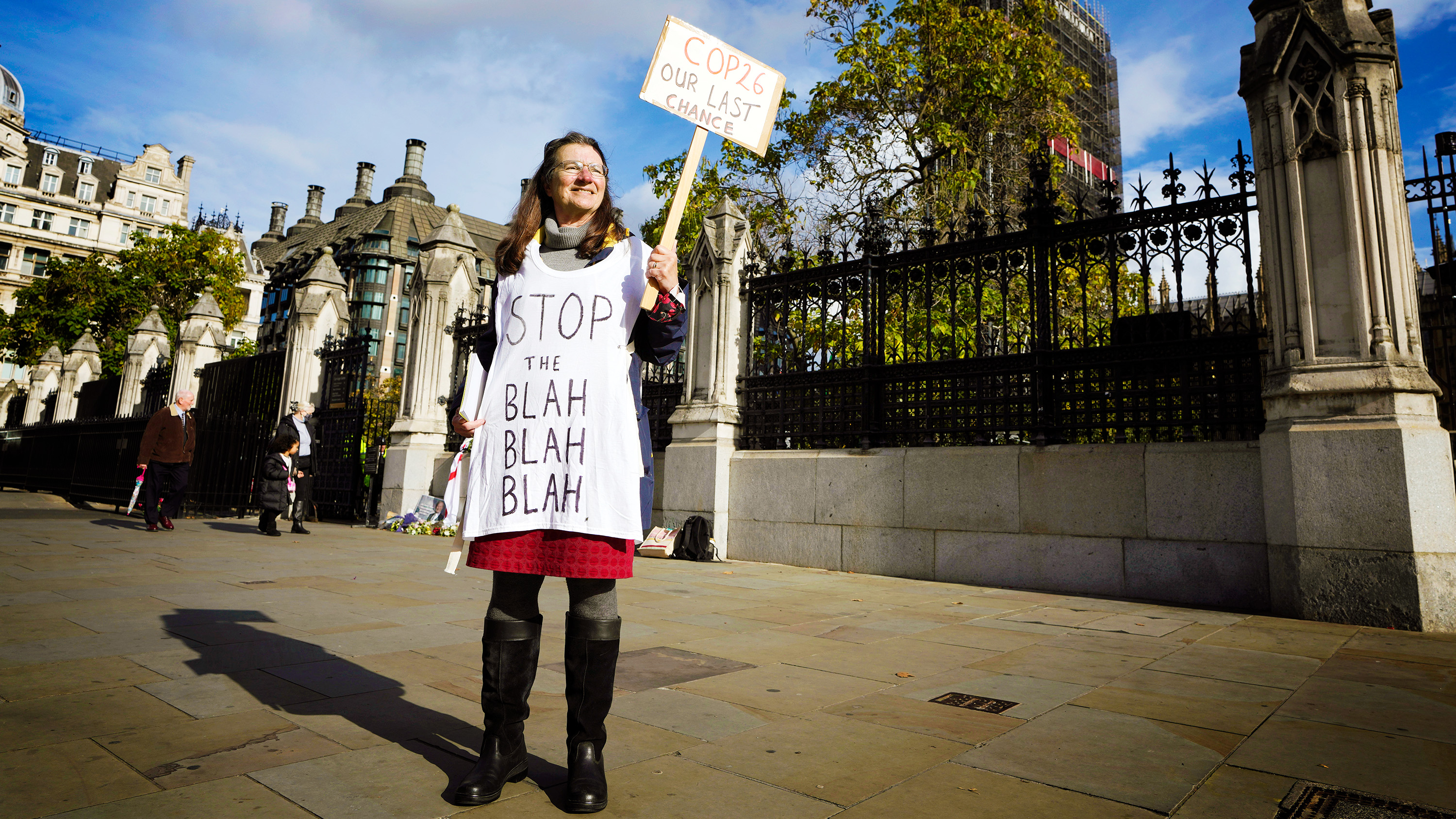 A lone climate demonstrator holds a banner outside parliament in London, Monday, Oct. 25, 2021, ahead of the UN climate conference COP26 that will be held in Glasgow, Scotland, next week.