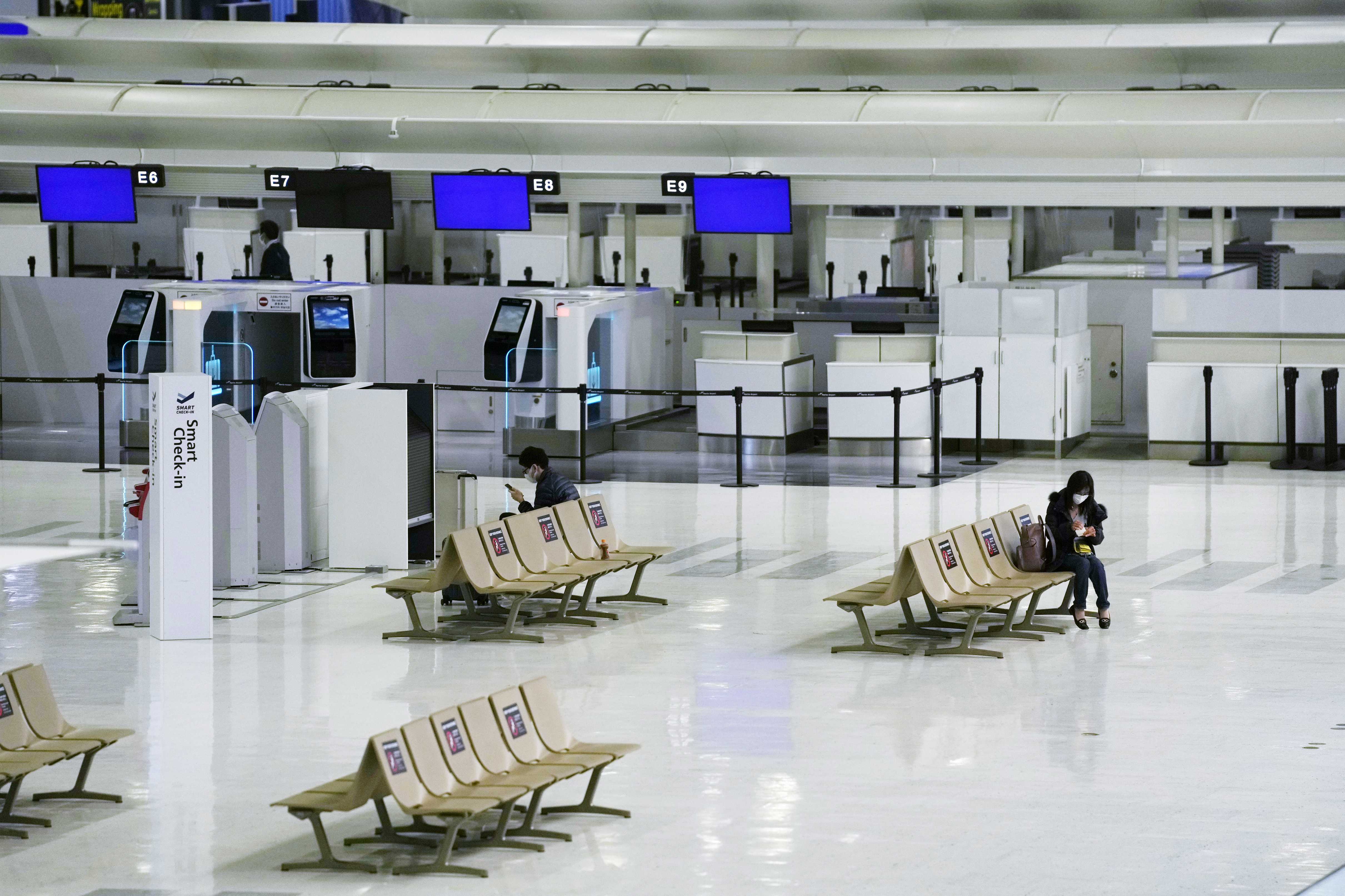 Passengers rest on the ticketing counter floor