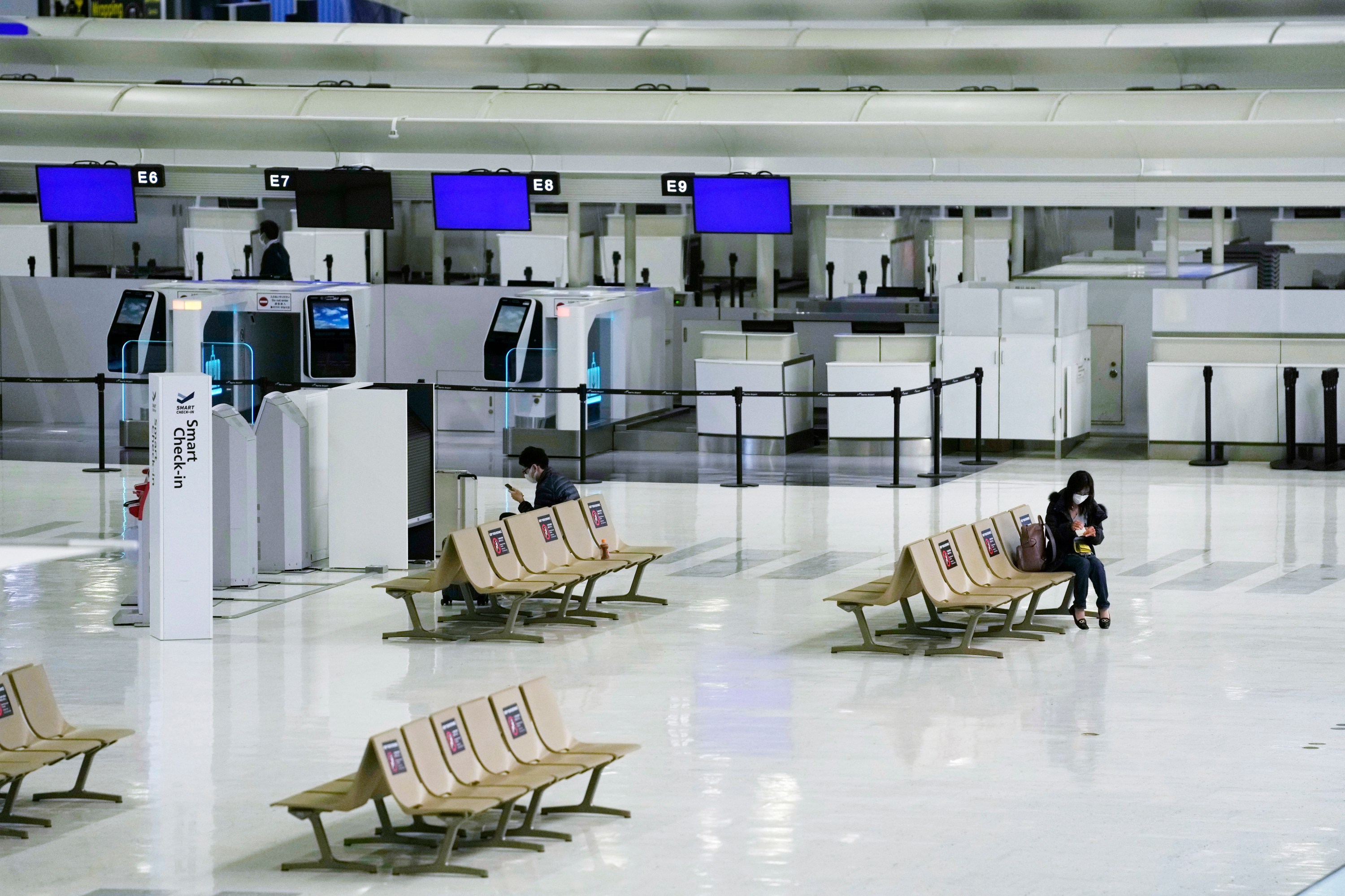 Passengers rest on the ticketing counter floor