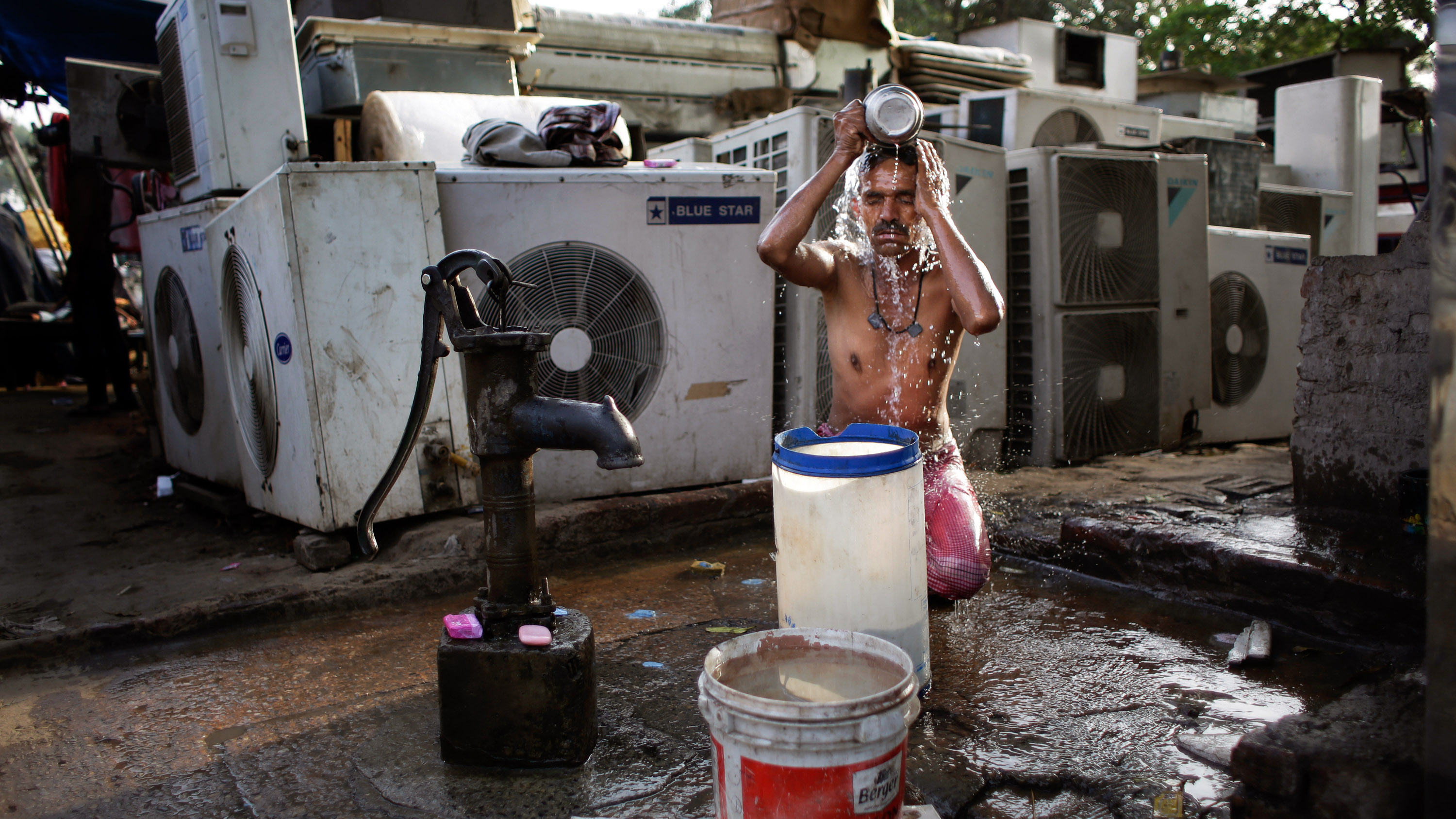 migrant worker in india pours water on his head during heat wave