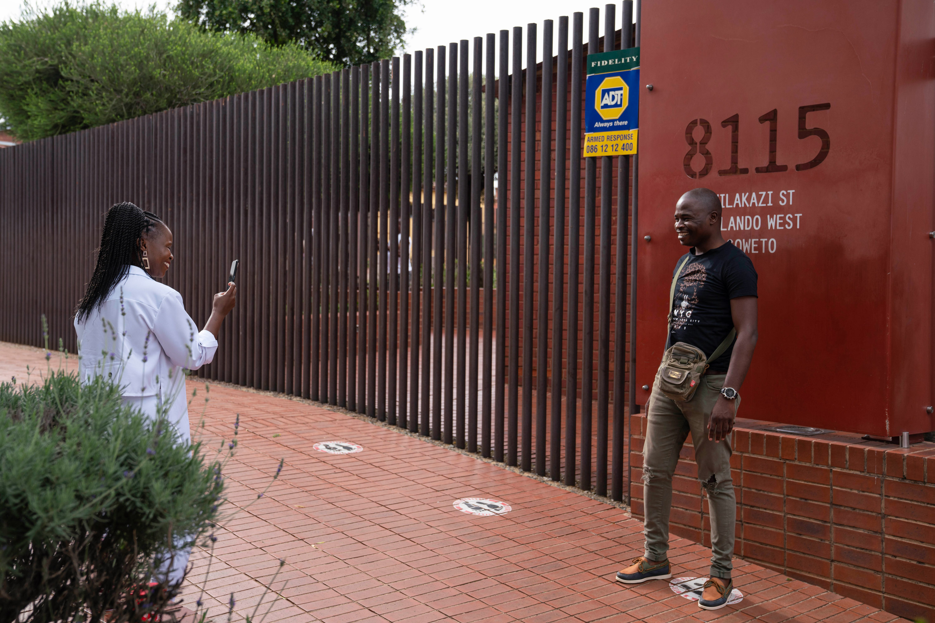 tourists take a photo outside gates of home