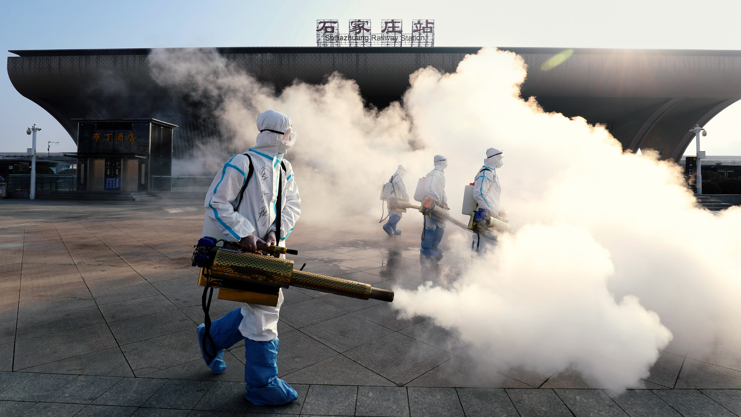 Workers disinfect the street outside Shijiazhuang Railway Station