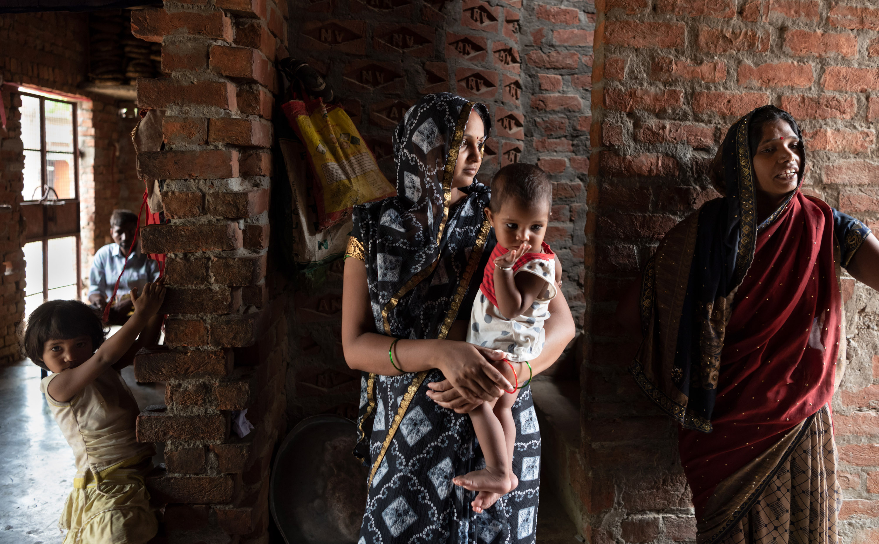 سومان شاكيا ، أم لطفلين ، تحمل طفلها في منزلها.
