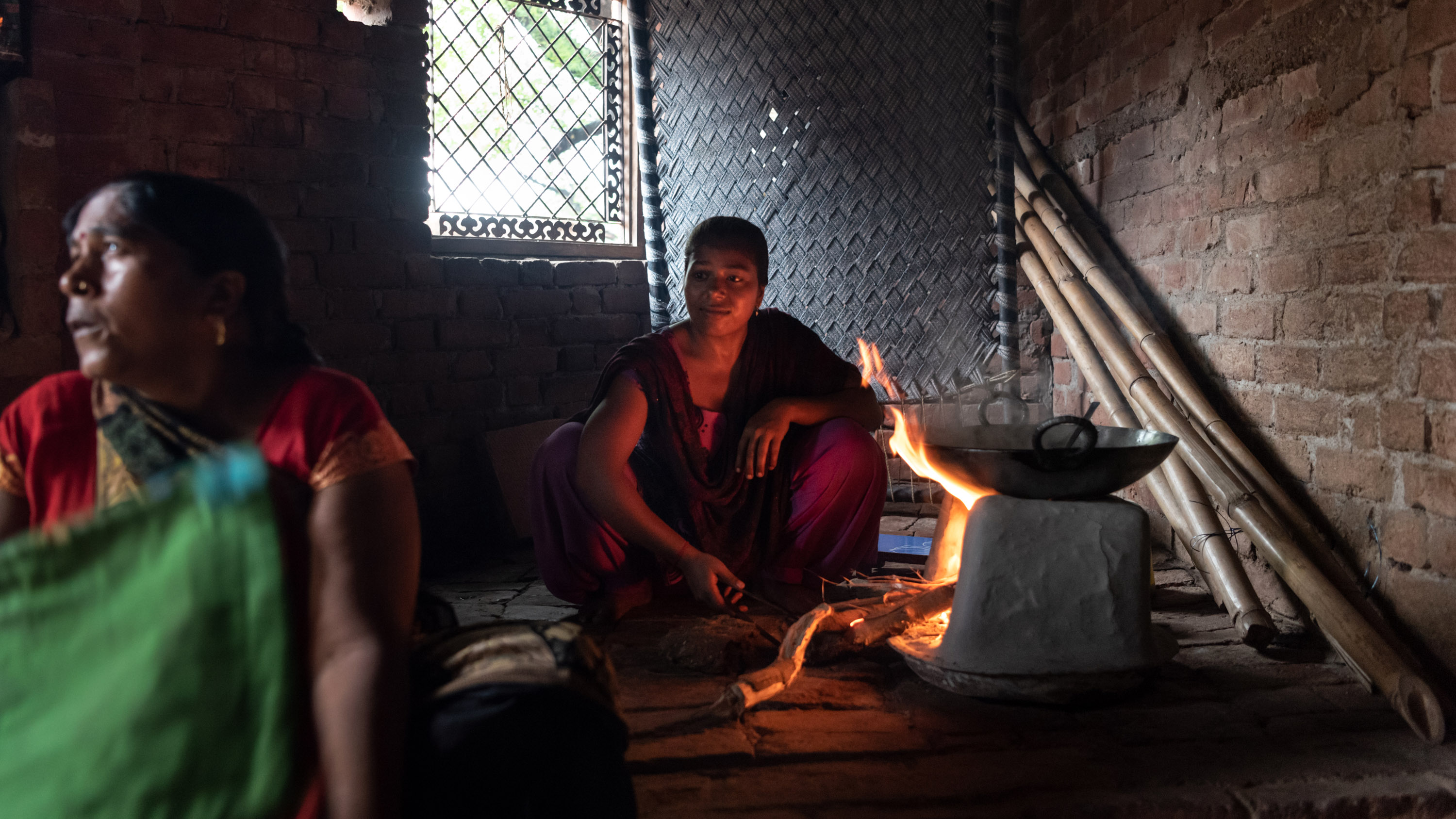Divya, 20, prepares a meal at her home in the sweltering heat