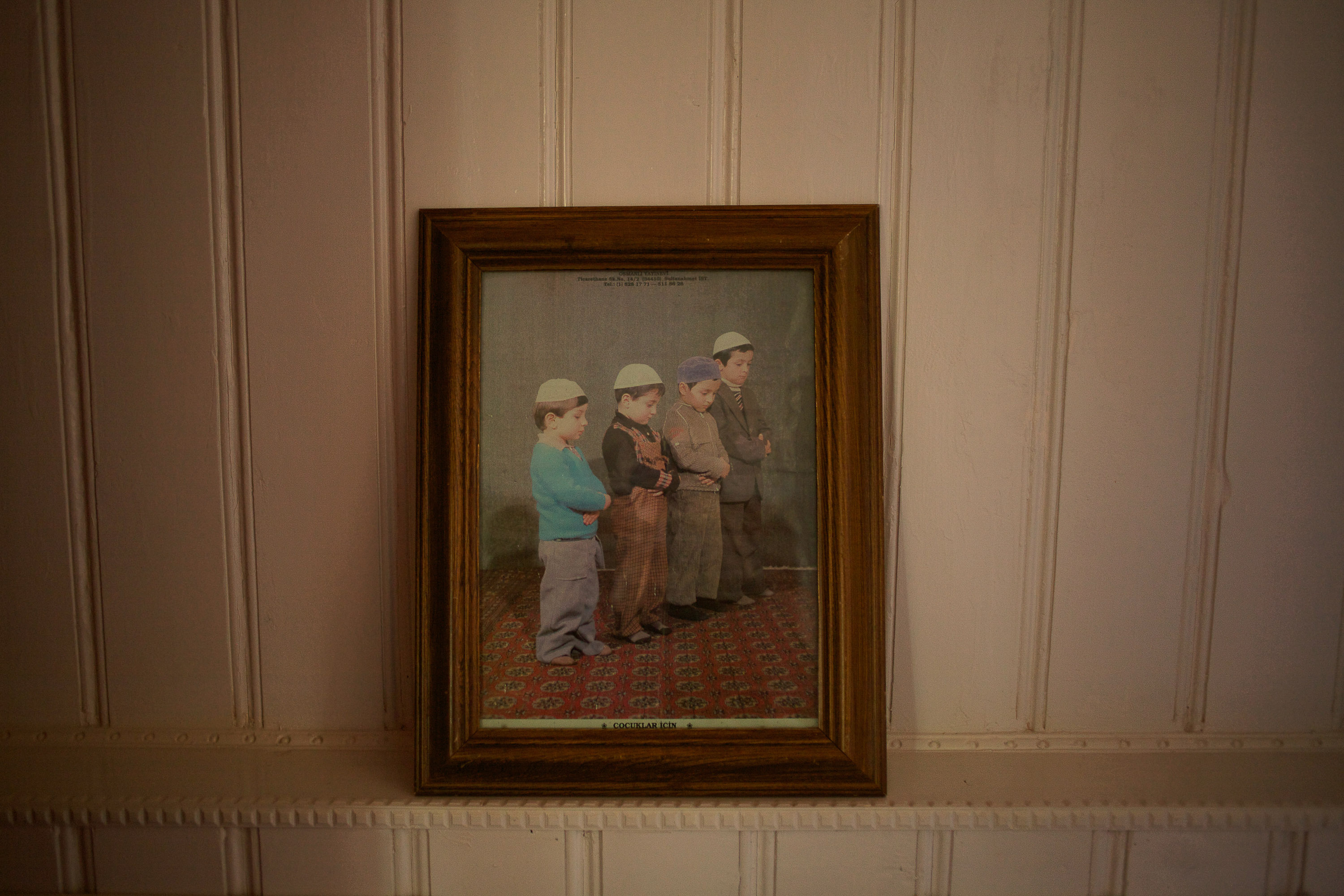 portrait of boys praying displayed on a mantel