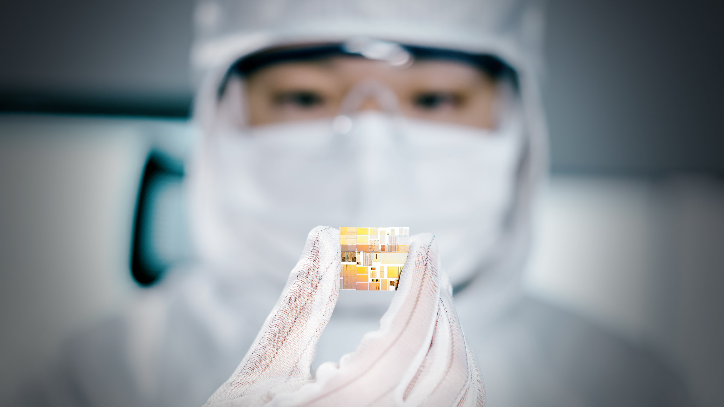 Close up of worker inspecting chip in a clean room