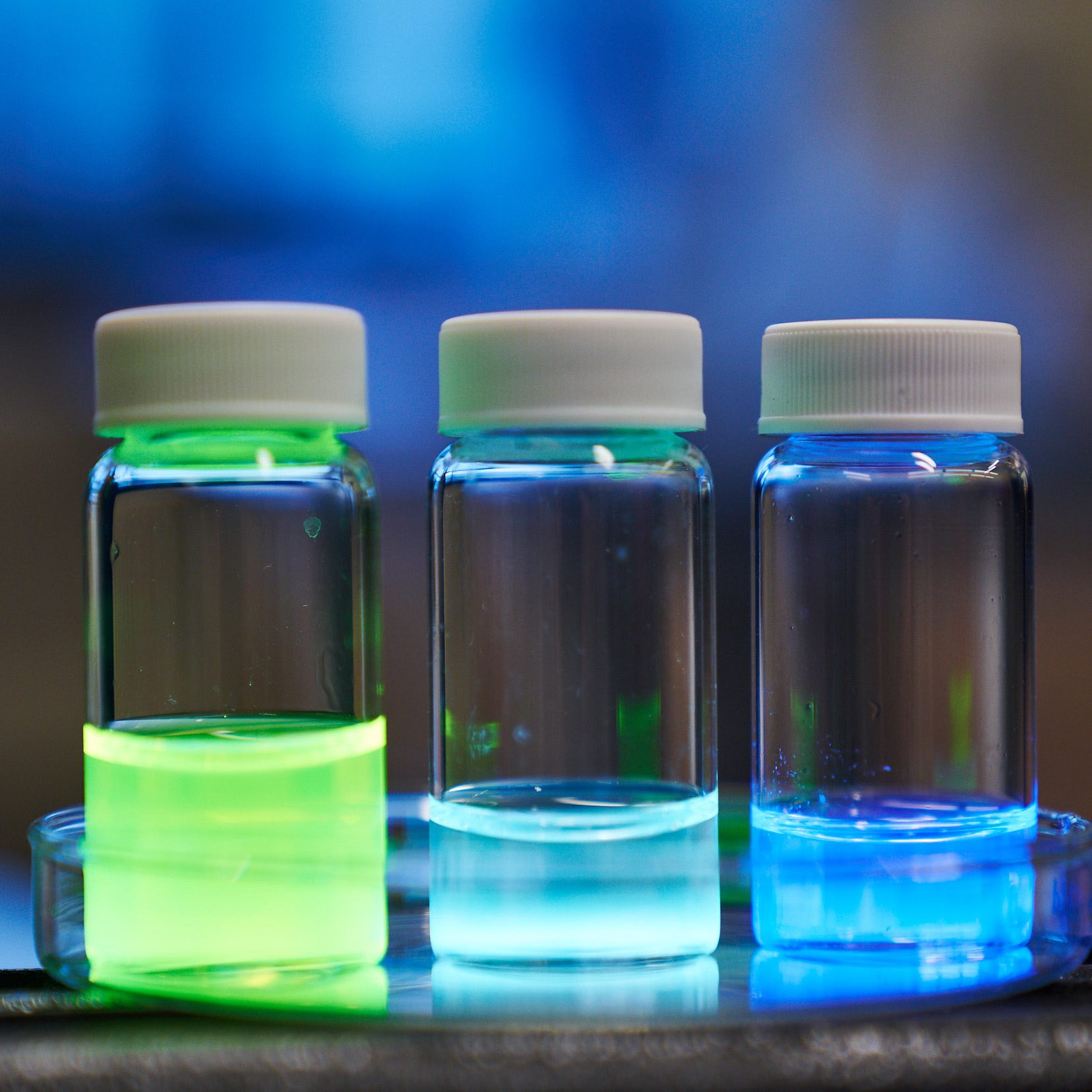 three vials of glowing liquid