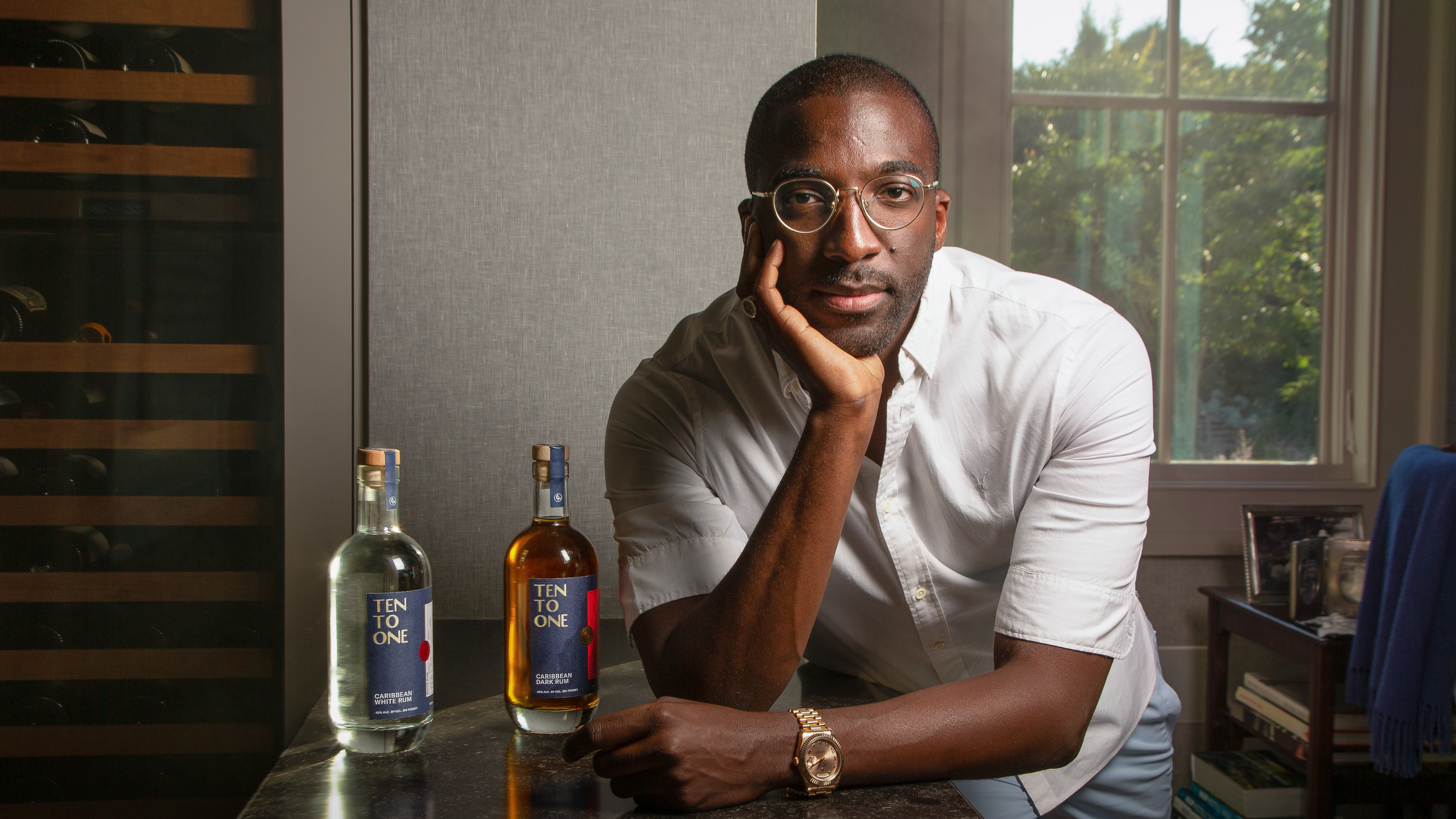 Marc Farrell portrait with bottles of his brand of rum
