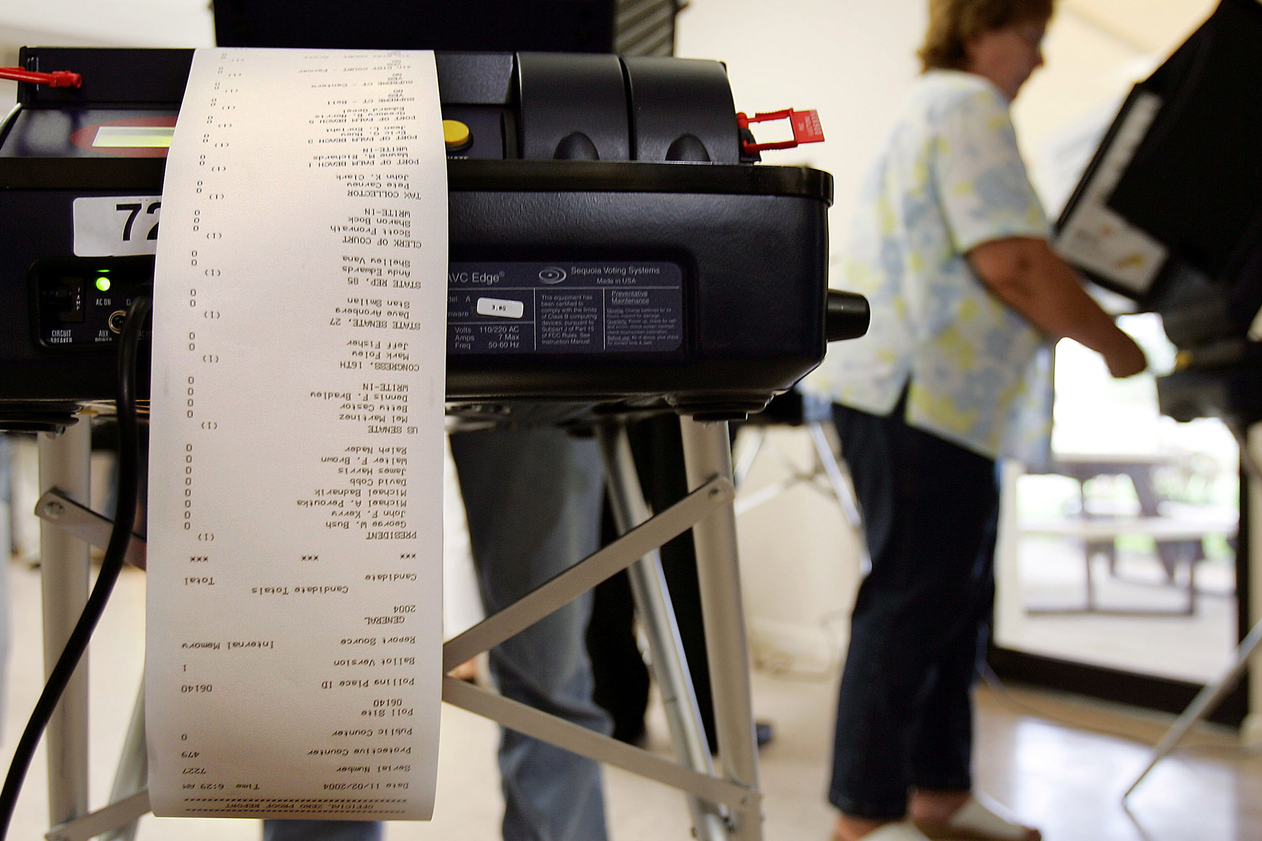 closeup of the back of electronic voting machine with paper receipt spooling out