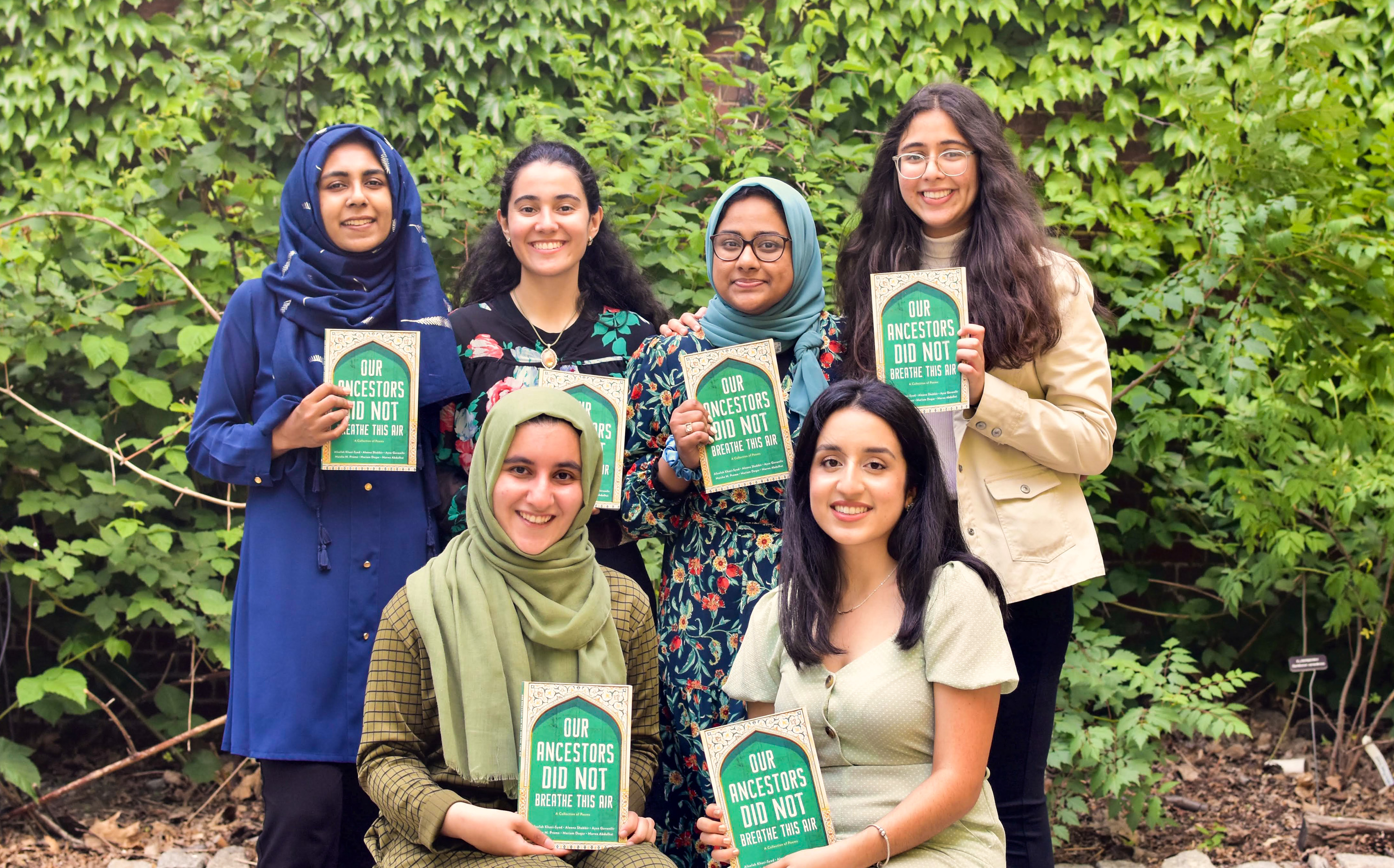 the 6 poets each holding a copy of the book