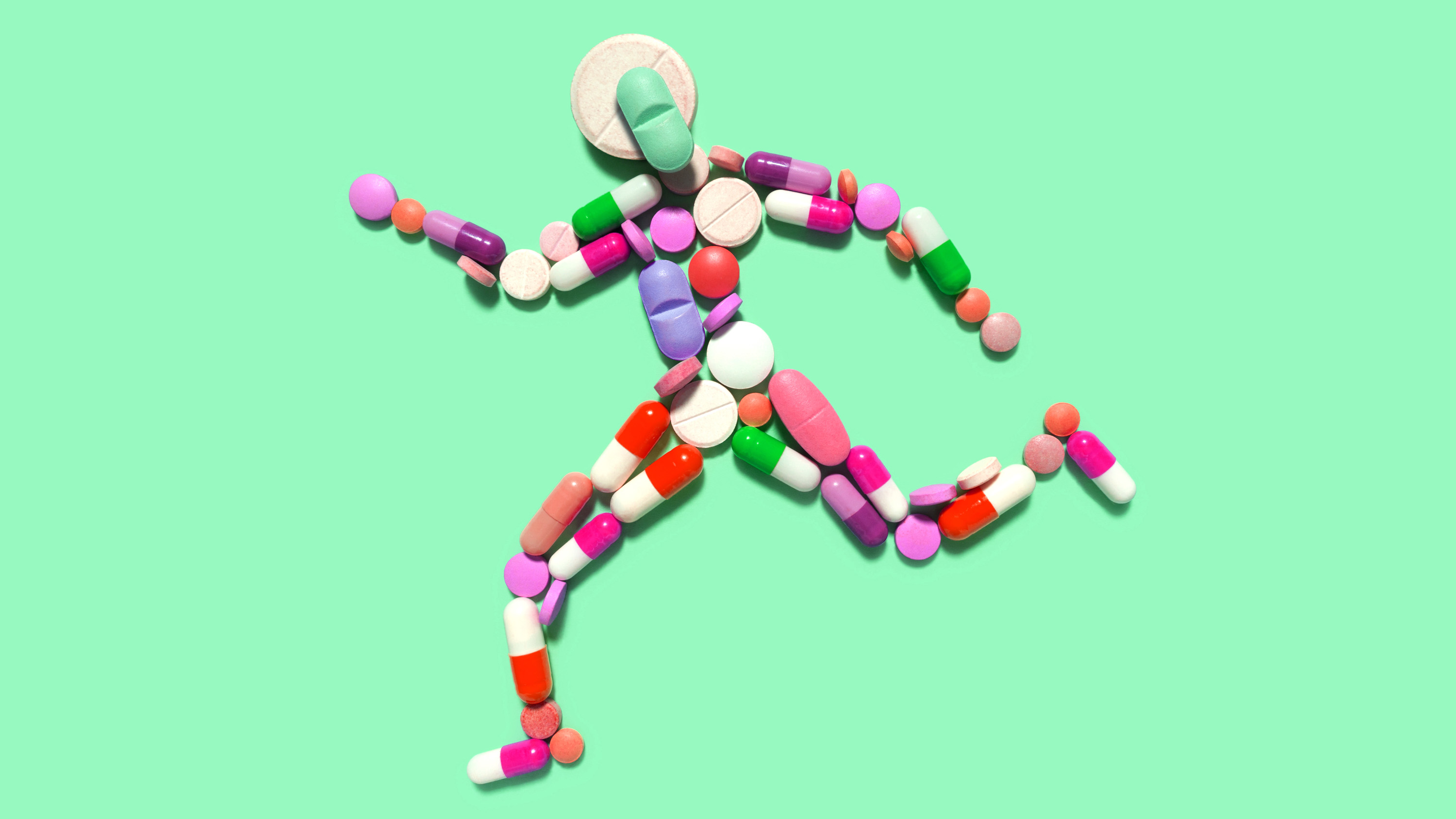 shape of person running made of colorful pills