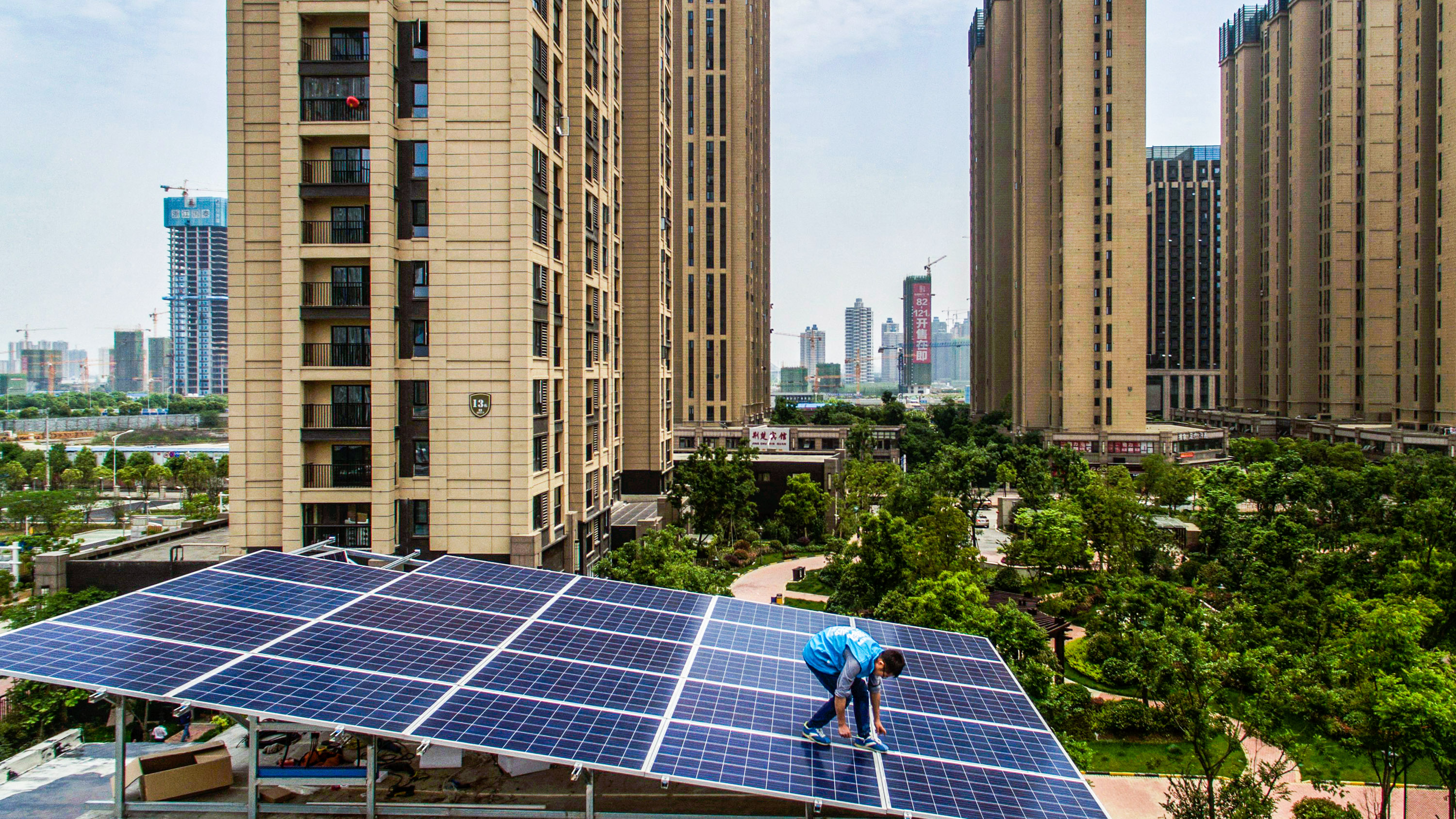 Workers of Wuhan Guangsheng Photovoltaic Company installed solar panels on the roof of the building