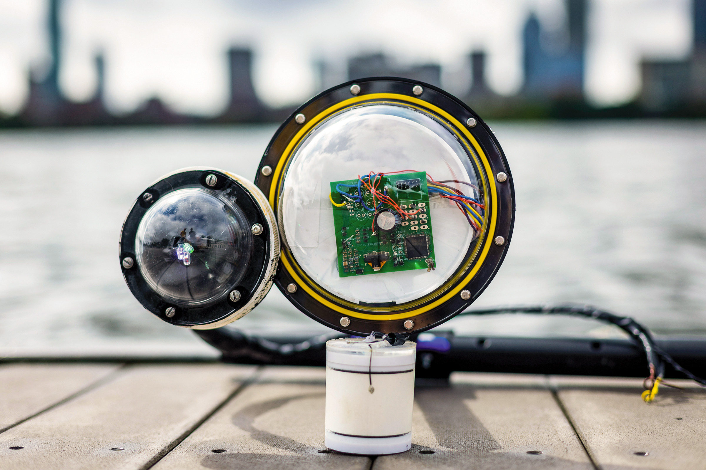 the protoype camera on the dock with the Boston skyline behind