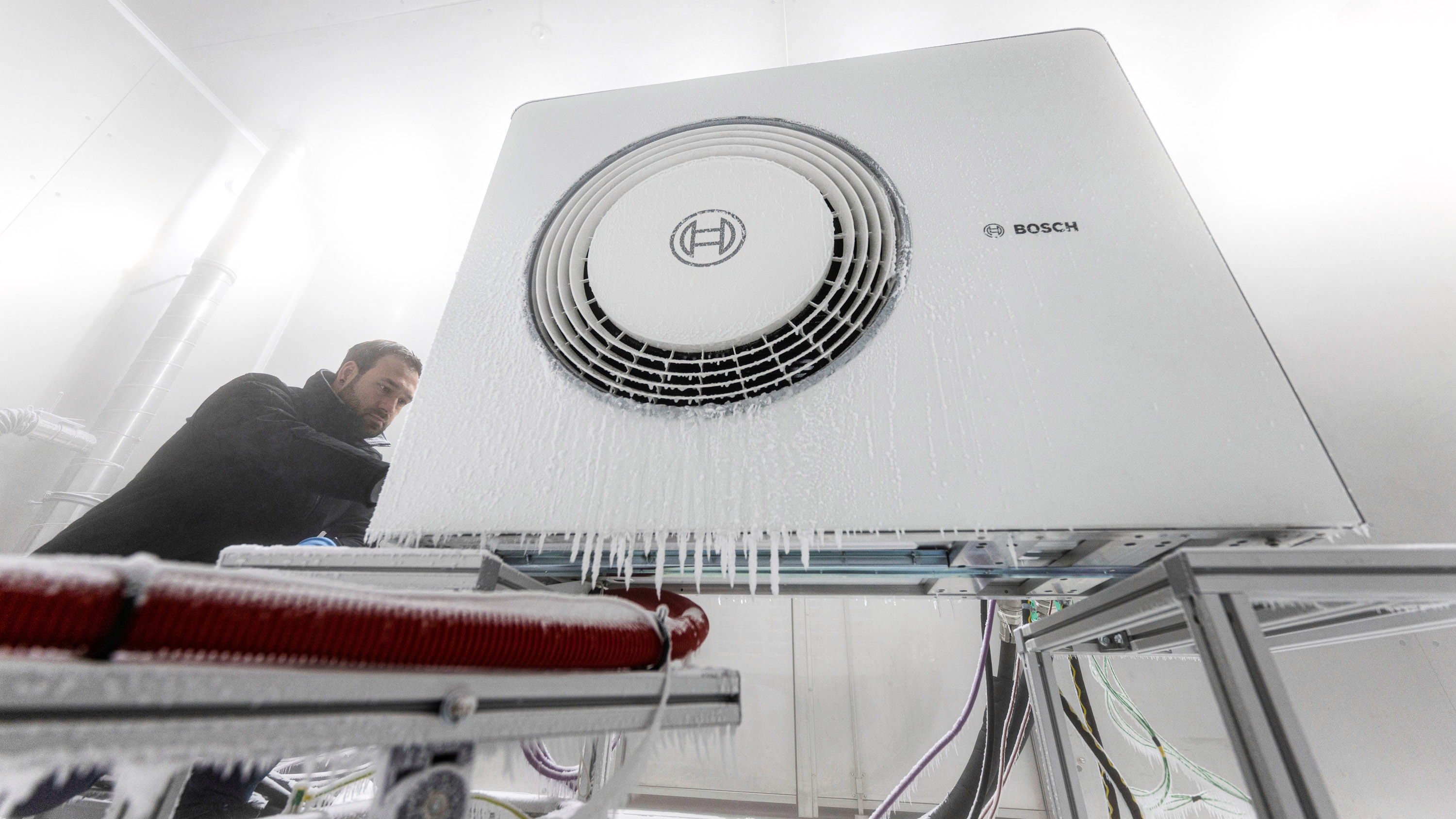 Bosch employee opening the housing of a heat pump in a cold chamber
