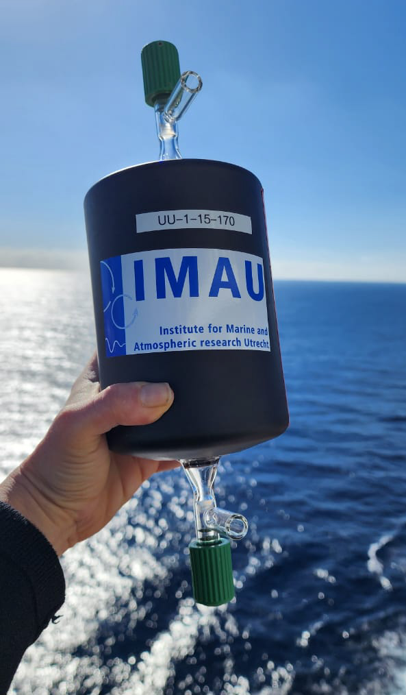 hand holding flask for ocean air collection with IMAU label