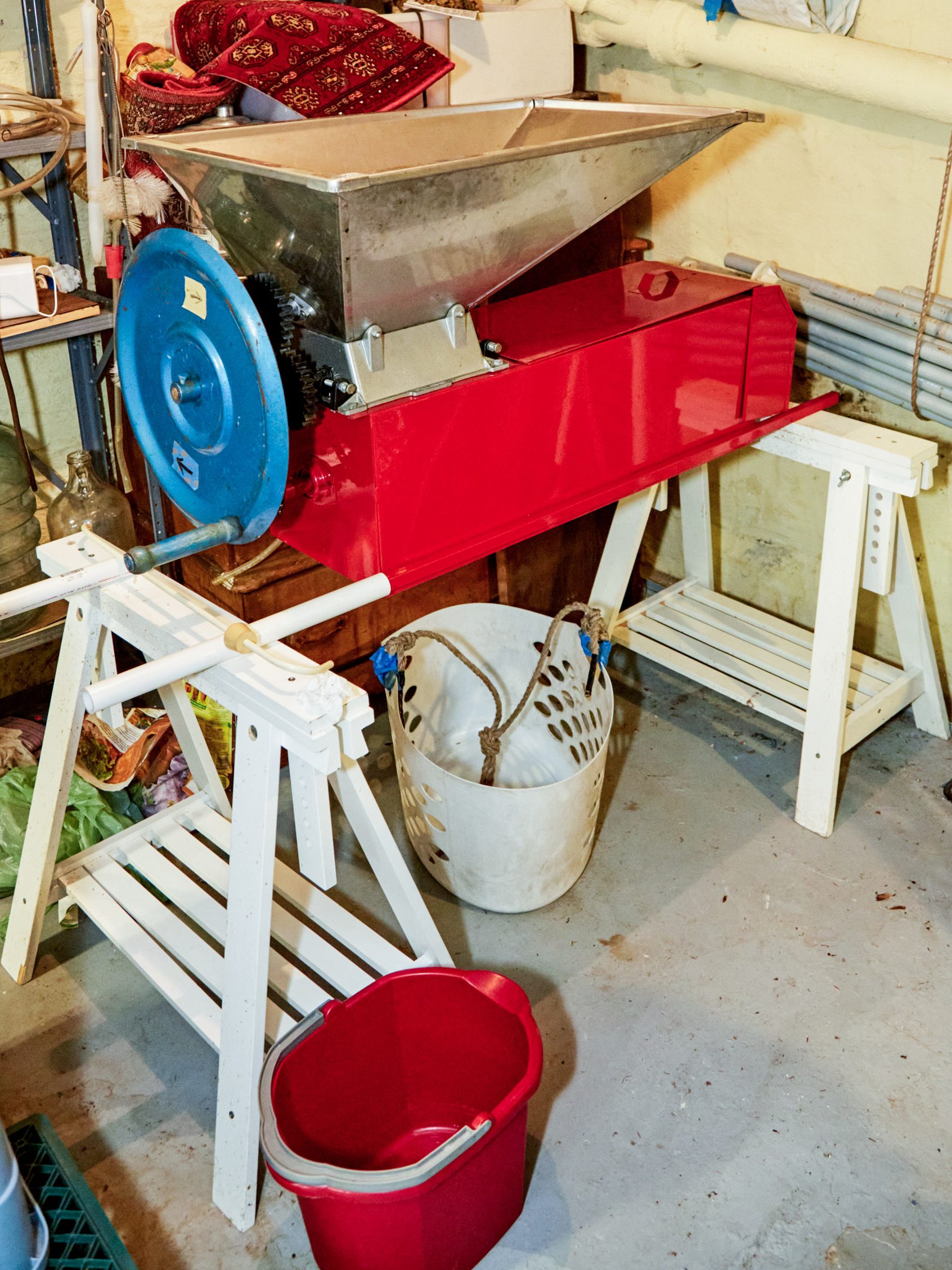 destemmer on a set of sawhorses, with several buckets around