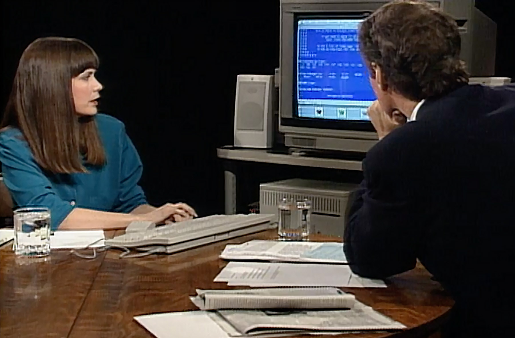 Horn and Charlie Rose on set during the filming of his show, looking at a computer screen.
