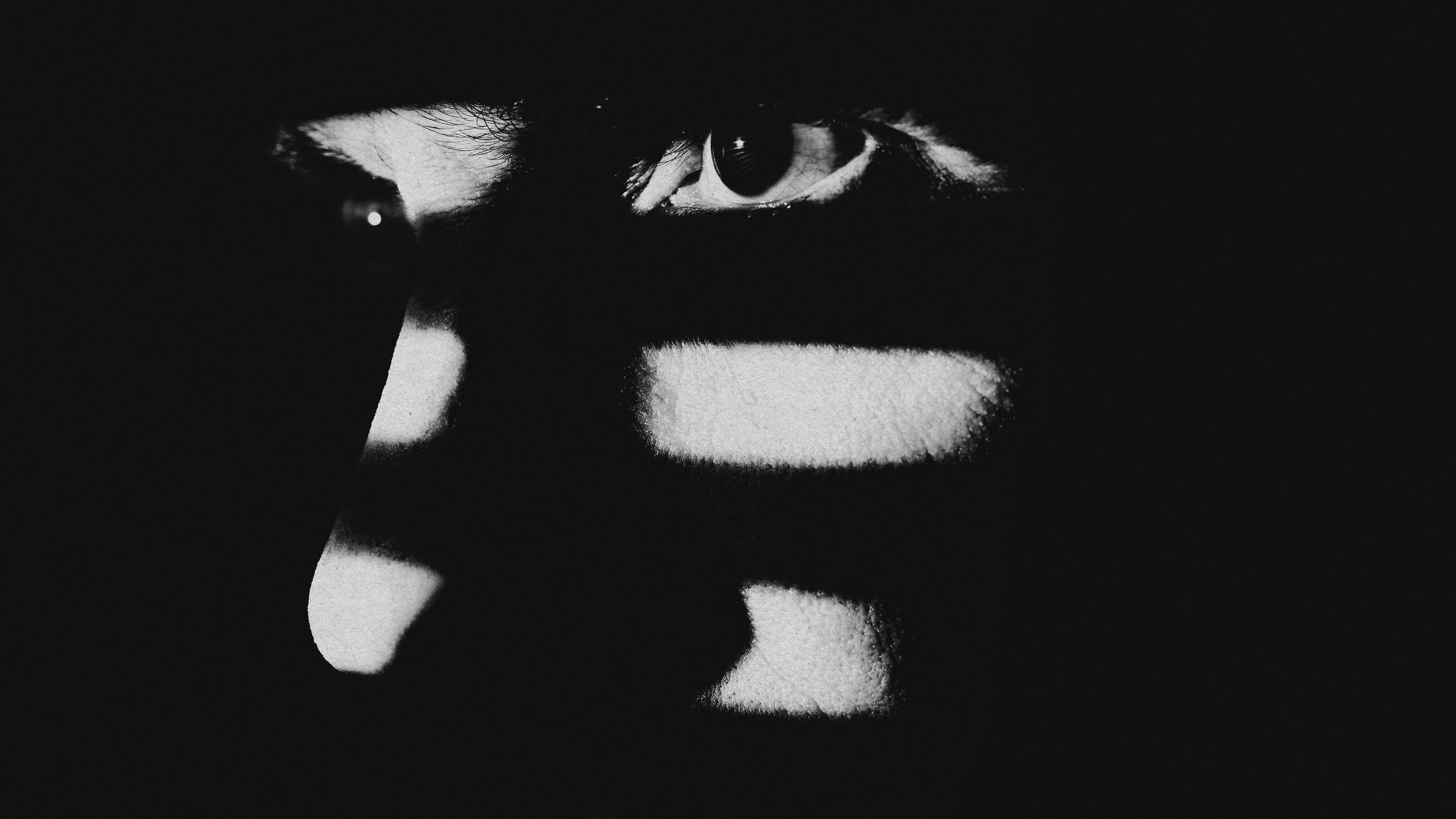 a man&#039;s face partially obscured by shadows