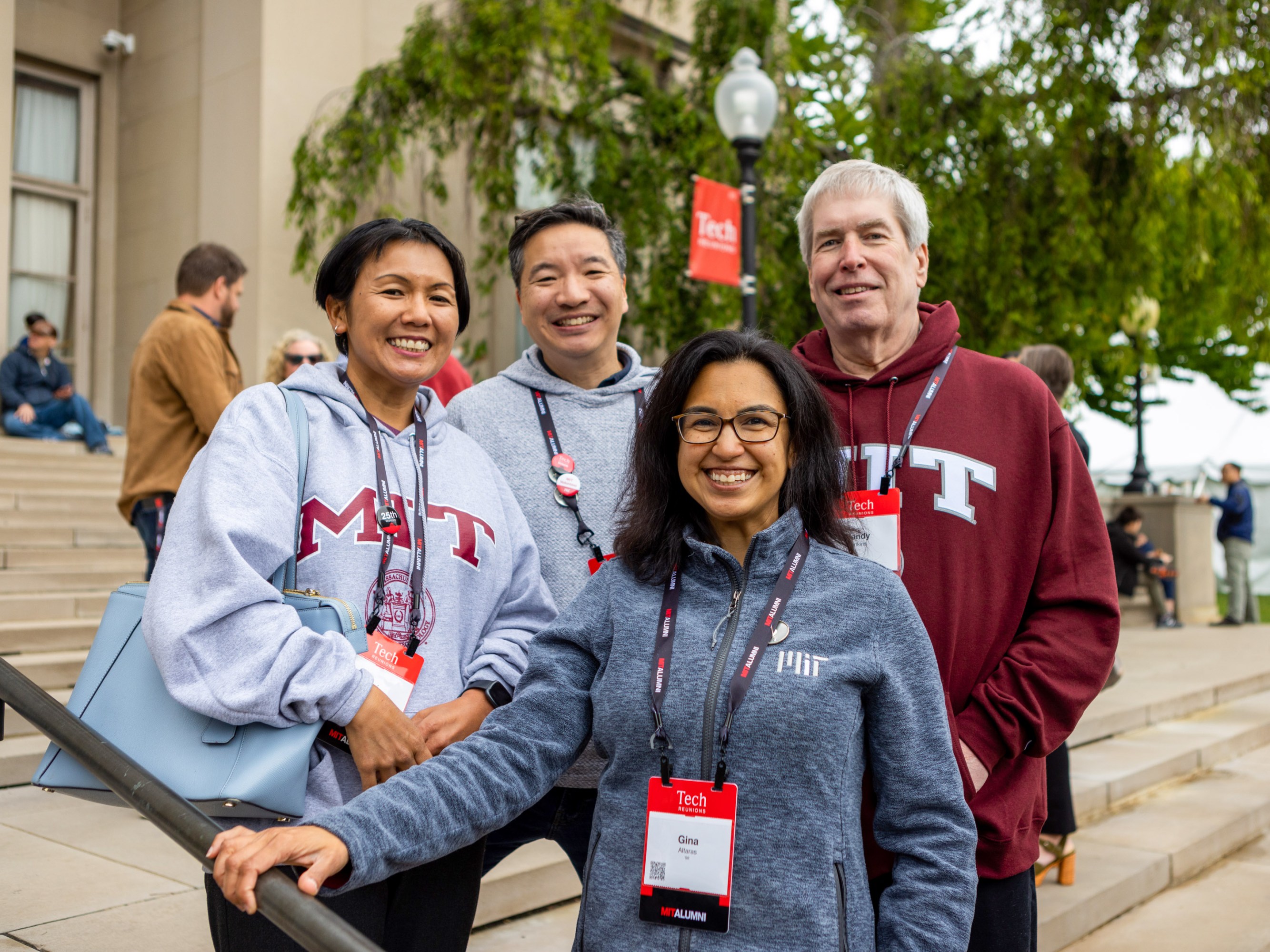Four people pose wearing MIT sweatshirts