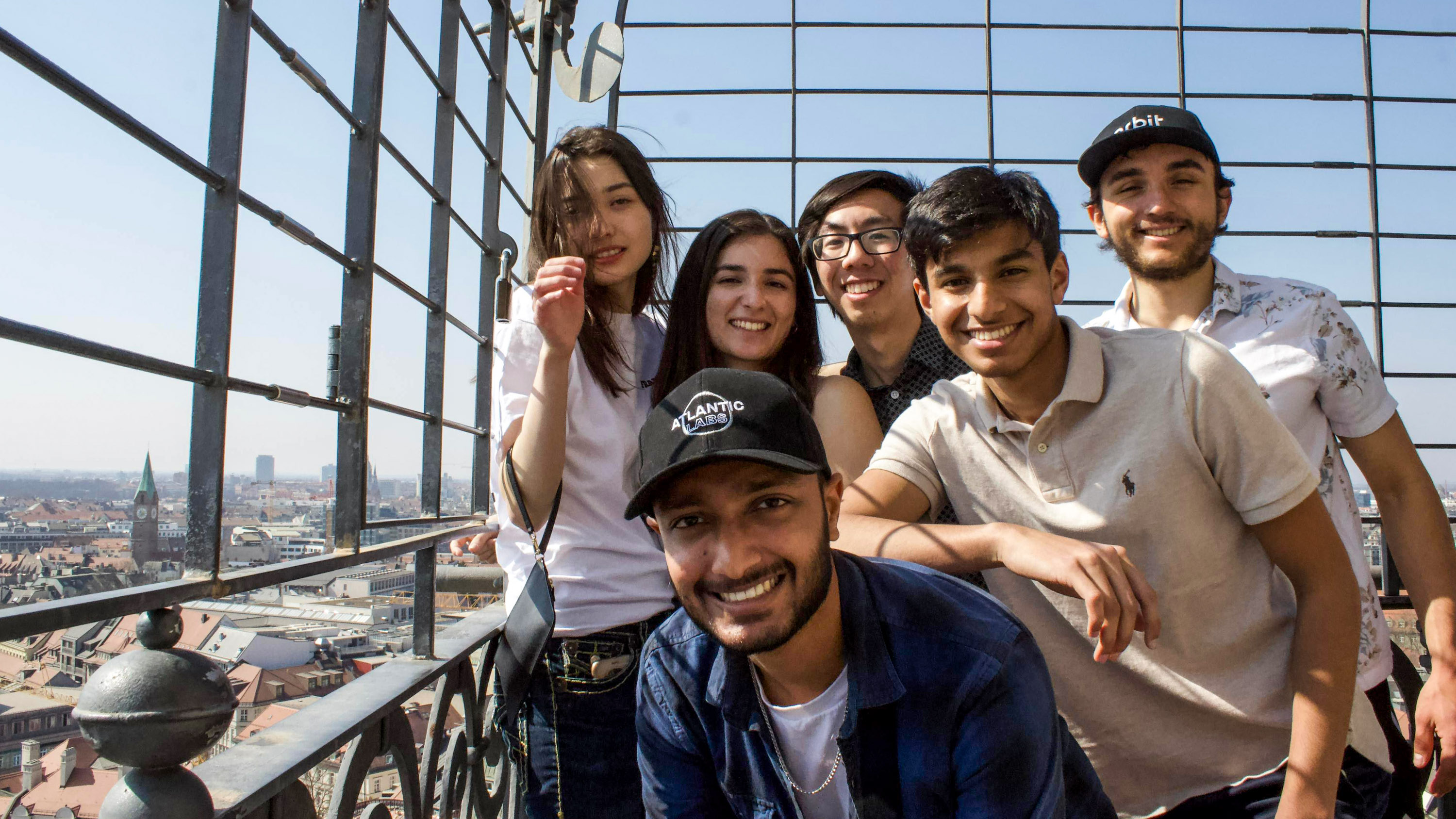 group of students posing on a viewing balcony overlooking a city