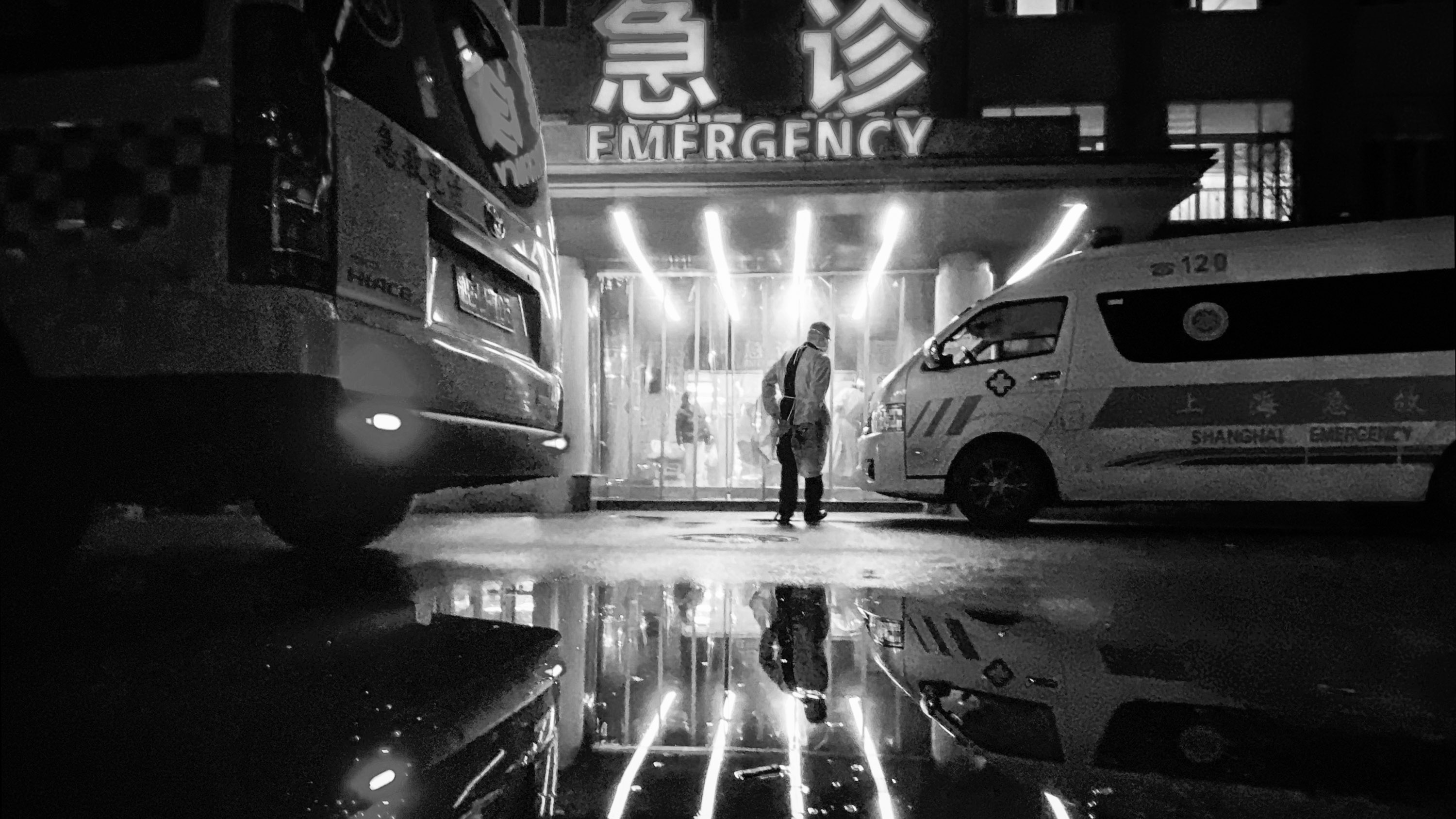 black and white image of an ambulance driver walking into an emergency area of a Shanghai hospital