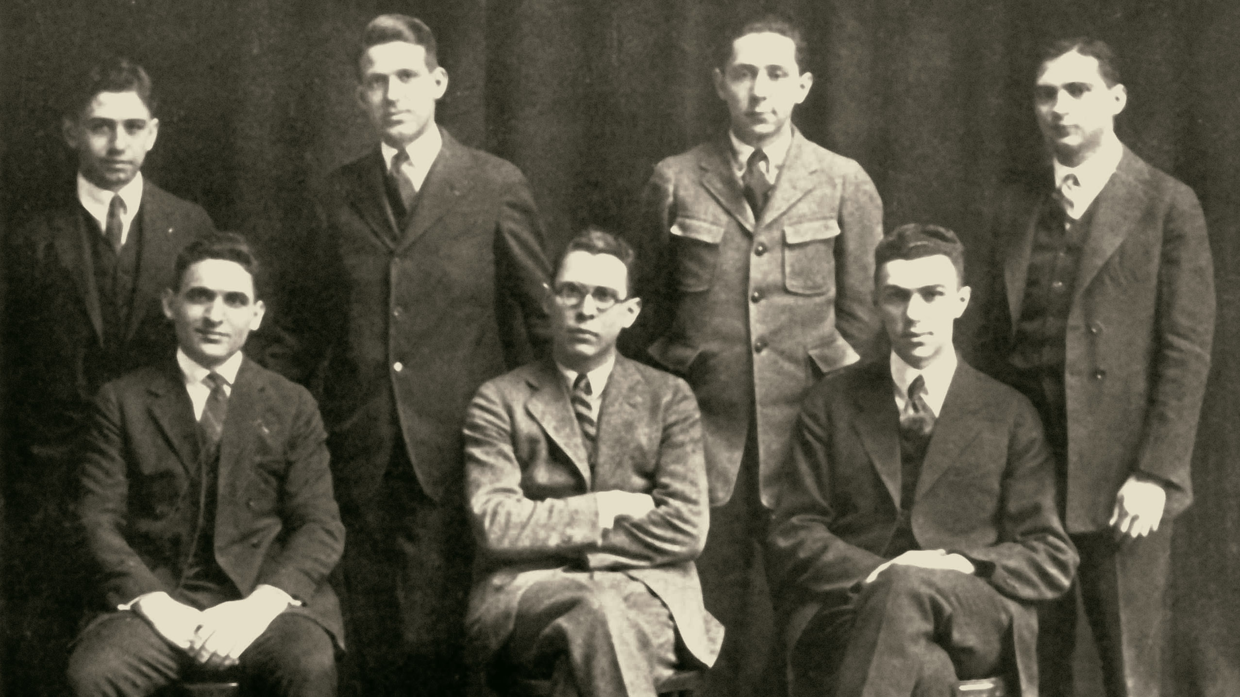 old black and white image of a group of seven men posed