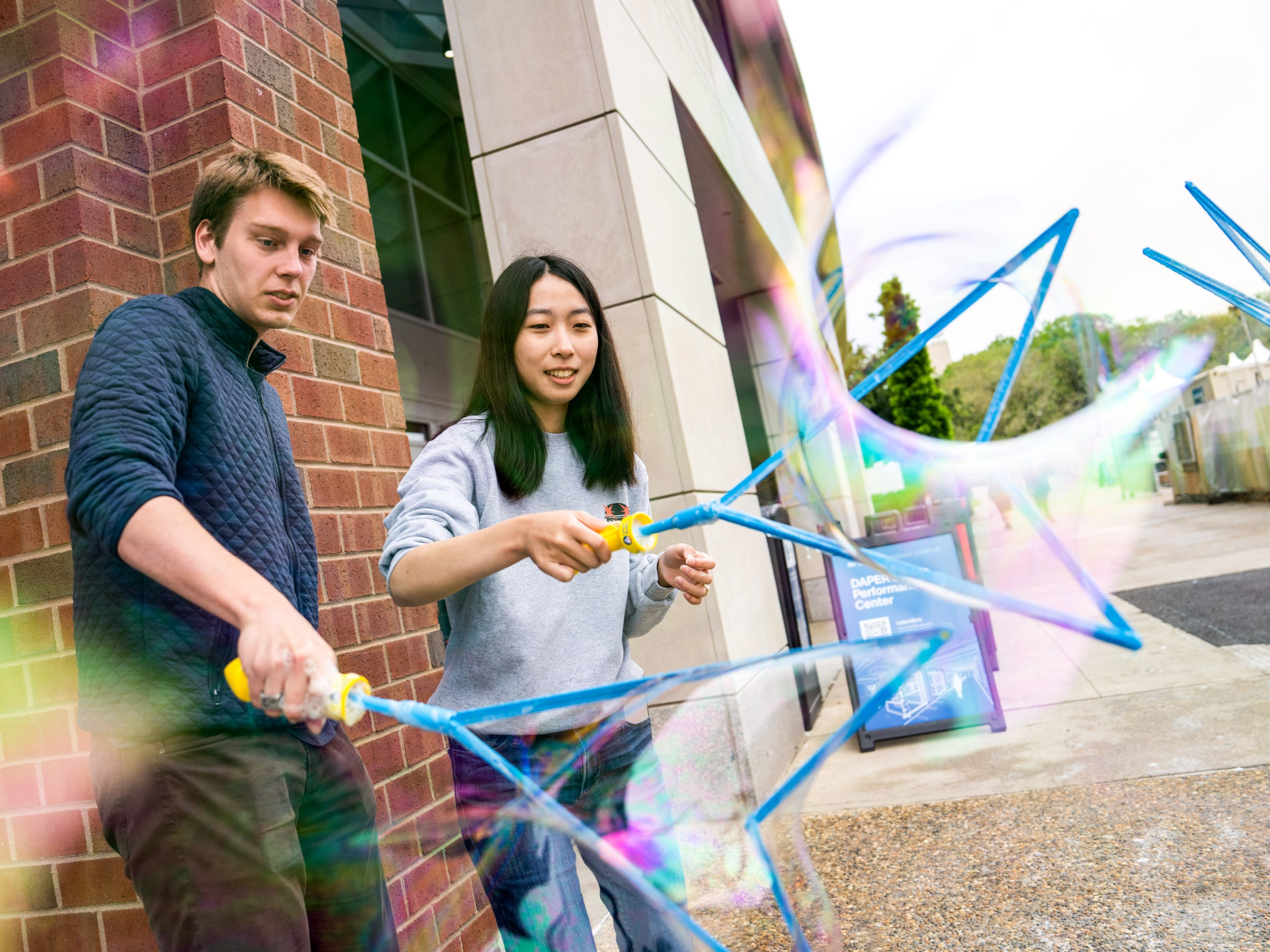 Two student using bubble wands